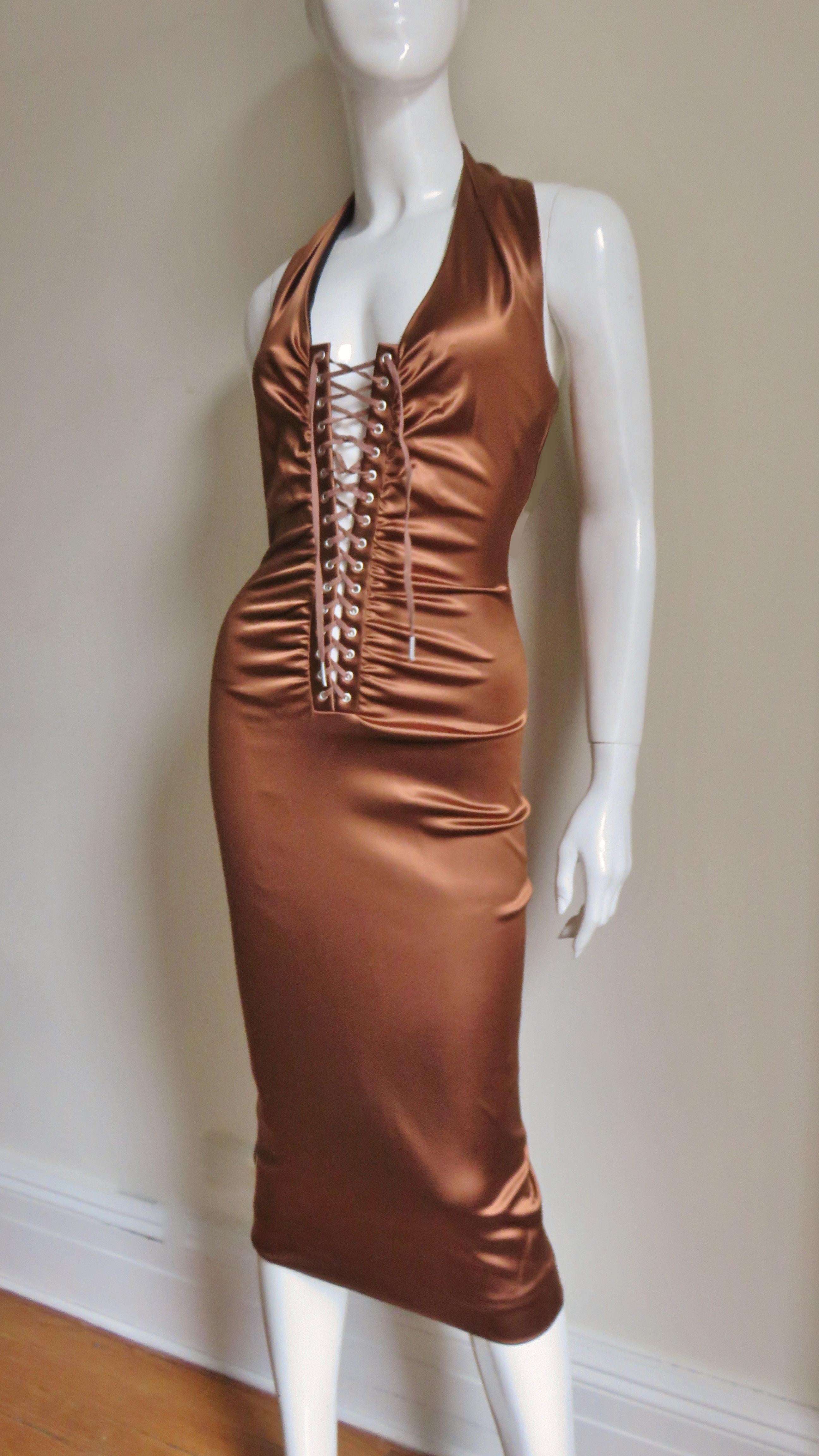 A fabulous halter style dress made of rich bronze stretch silk for a great fit from Dolce & Gabbana.   It has a front placket with adjustable lacing to show more or less decolletage as desired from which ruching emanates through to the hips.  It has