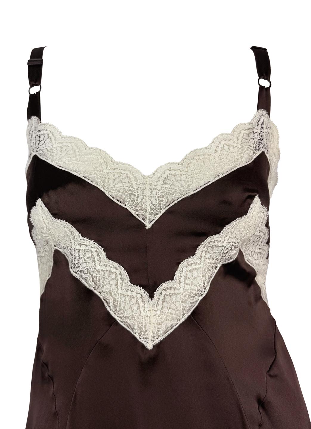 This 1990s Dolce & Gabbana mini slip dress is crafted from brown silk satin with delicate white lace trim. The lingerie-inspired design features adjustable straps, a soft bustline, and a flared hem, showcasing the brand’s signature sensual and