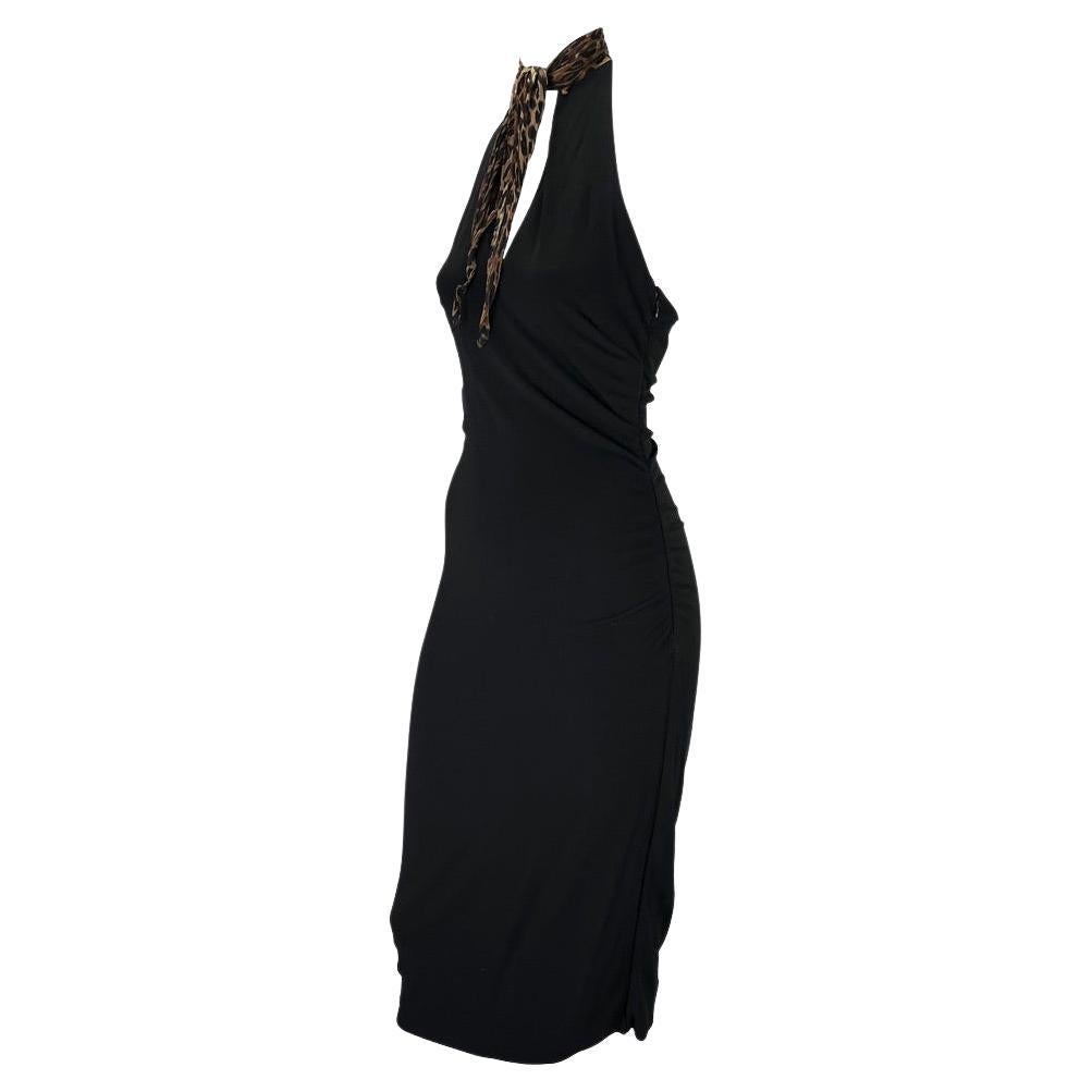 Presenting a formfitting black Dolce and Gabbana halter neck dress with a leopard print necktie. This dress is semi-ruched from the Fall/Winter 2001 collection with fabric gathered at the side seams. The leopard print necktie is connected to the