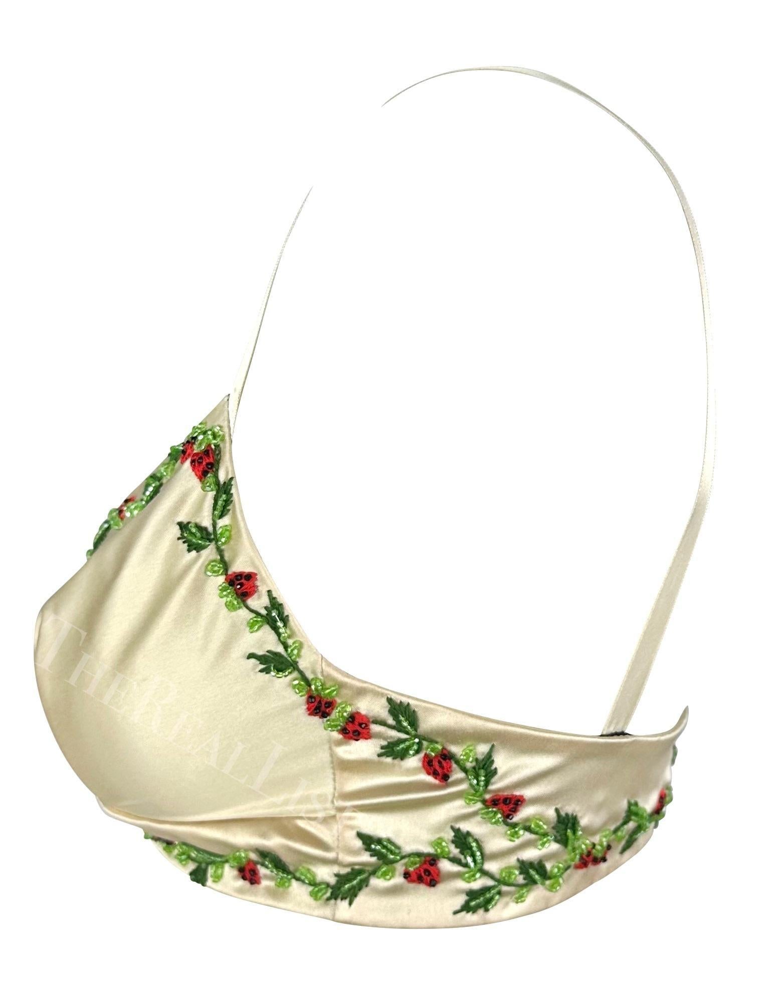 Voici une superbe bralette Dolce & Gabbana en satin crème. Datant de la fin des années 1990, cette fabuleuse bralette est fabriquée en satin crème brillant et est agrémentée d'une garniture perlée en forme de fraise. Portée en couches ou seule,