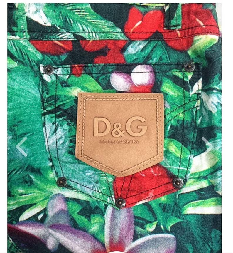 Wunderschöner Minirock mit tropischem Blumendruck von DOLCE&GABBANA mit folgenden Eigenschaften: Reißverschluss auf der Vorderseite, 3 Taschen auf der Vorderseite, Metallwaren, 2 Gesäßtaschen mit Designerlogo aus Leder, leichtes Gewicht, Made in