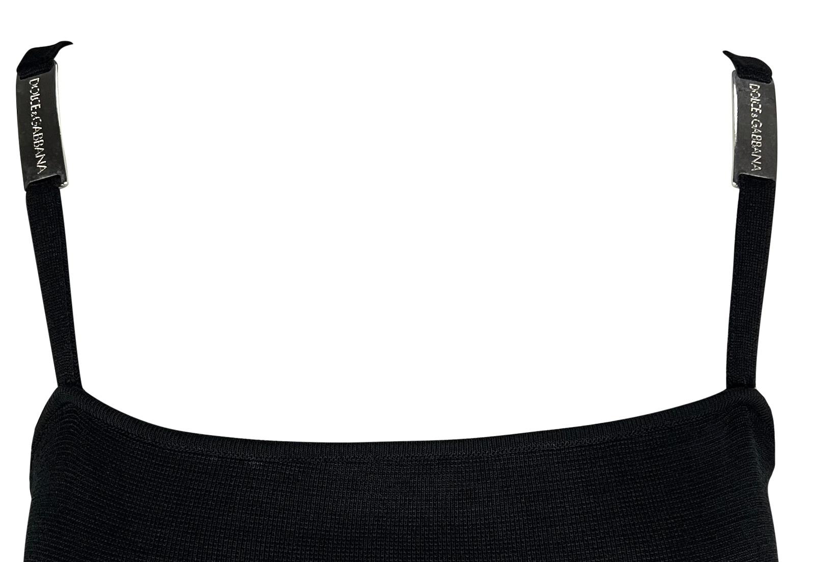 Dieses Dolce & Gabbana-Minikleid aus den 1990er-Jahren ist aus schwarzem Strick gefertigt und im Schlupfstil gehalten. Dieses figurbetonte Kleid ist an den Trägern mit metallischen Markenakzenten verziert. 

Ungefähre Maße:
Größe - 42IT
Brustumfang: