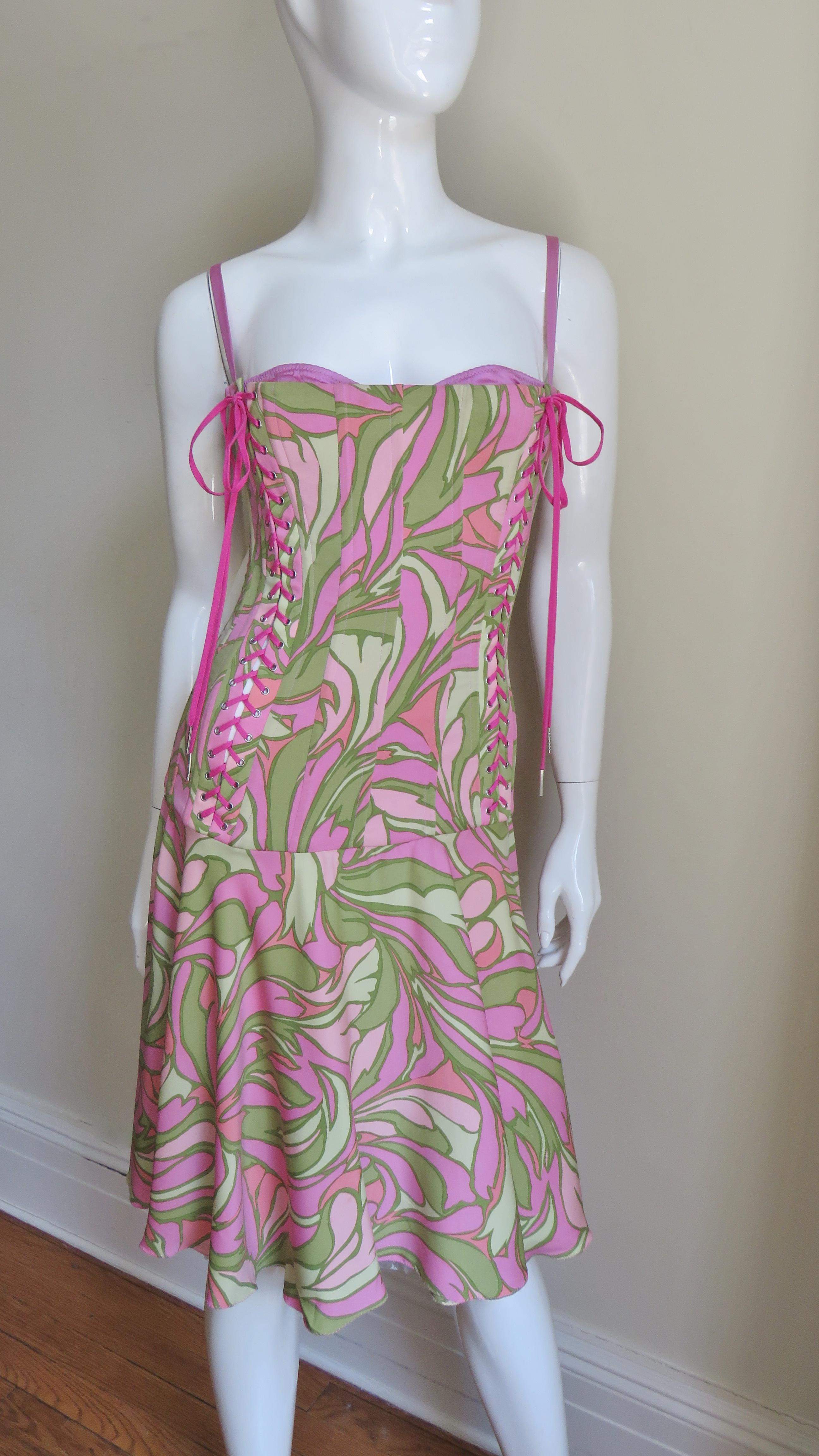 A beautiful pinks and greens geometric stretch silk print dress from Dolce & Gabbana.  It is fitted through the dropped waist torso and boned vertically throughout.  There is an attached matching pink fully adjustable bra which peeks out of the top