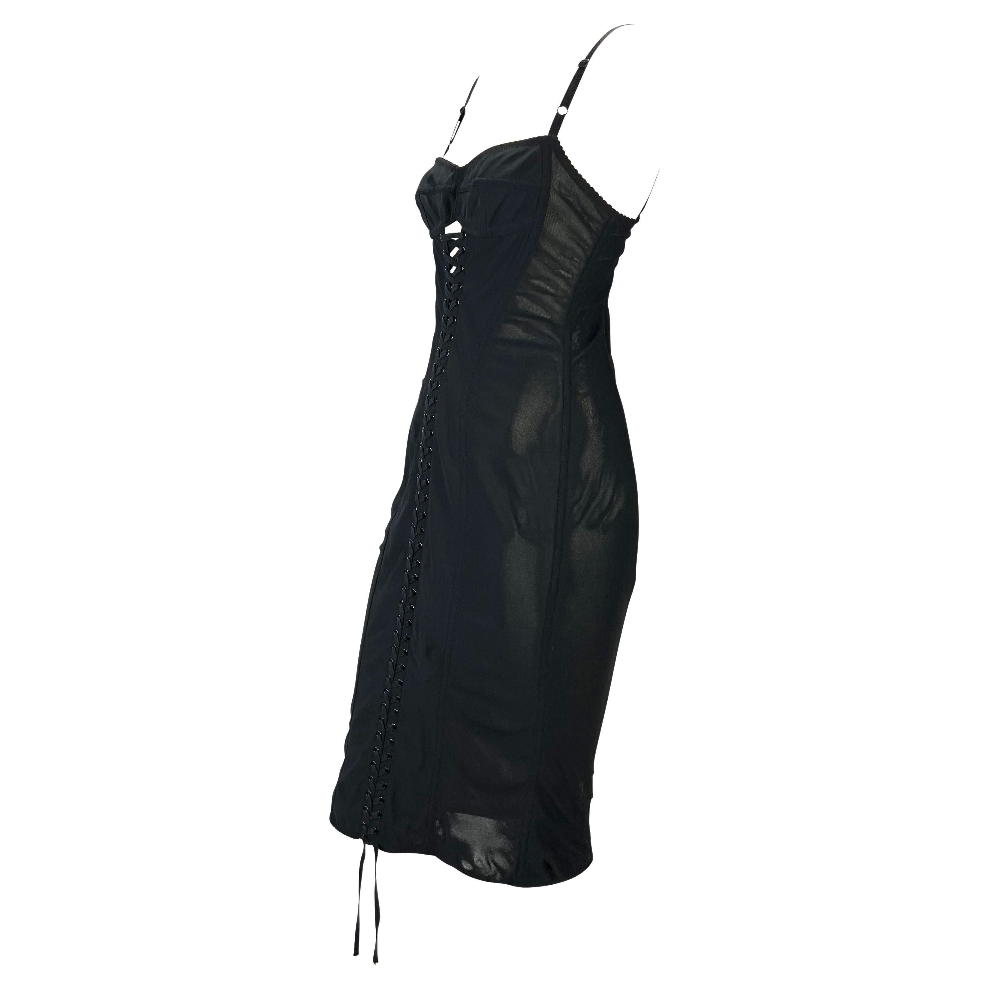 Presenting a stunning black lace-up Dolce and Gabbana dress. From the 1990s, this beautiful dress boldly features Dolce and Gabbana's infamous lace-up detail at the front of the dress which holds together semi-sheer mesh panels. The dress is made