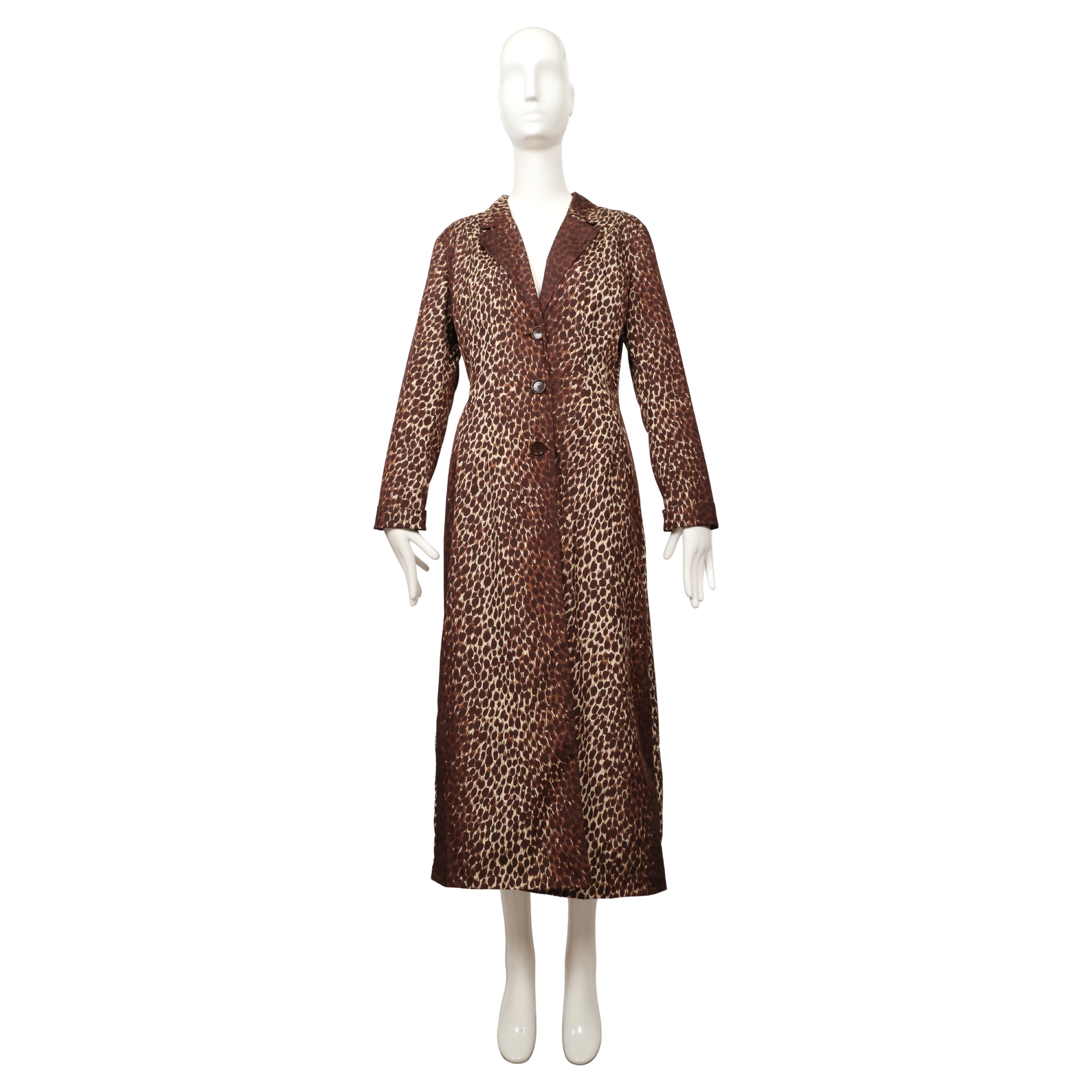 Ce manteau Dolce & Gabbana des années 1990 est confectionné en nylon imprimé d'un motif léopard marron et beige. Il présente une coupe longue et mince avec un col cranté, trois boutons sur le devant et des manches ajustées qui peuvent être