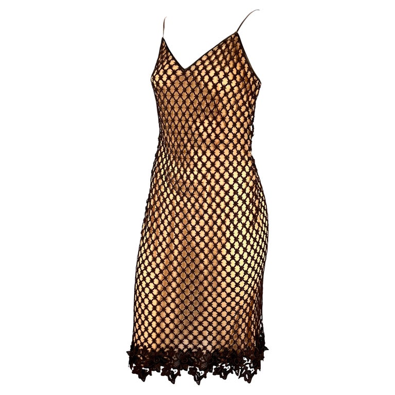 TheRealList presents: a tan Dolce and Gabbana slip dress with brown lace overlay. From the 1990s, this incredible dress is constructed of a beige/peach slip with brown lace on top and features spaghetti straps and a v-neckline. Dolce and Gabbana