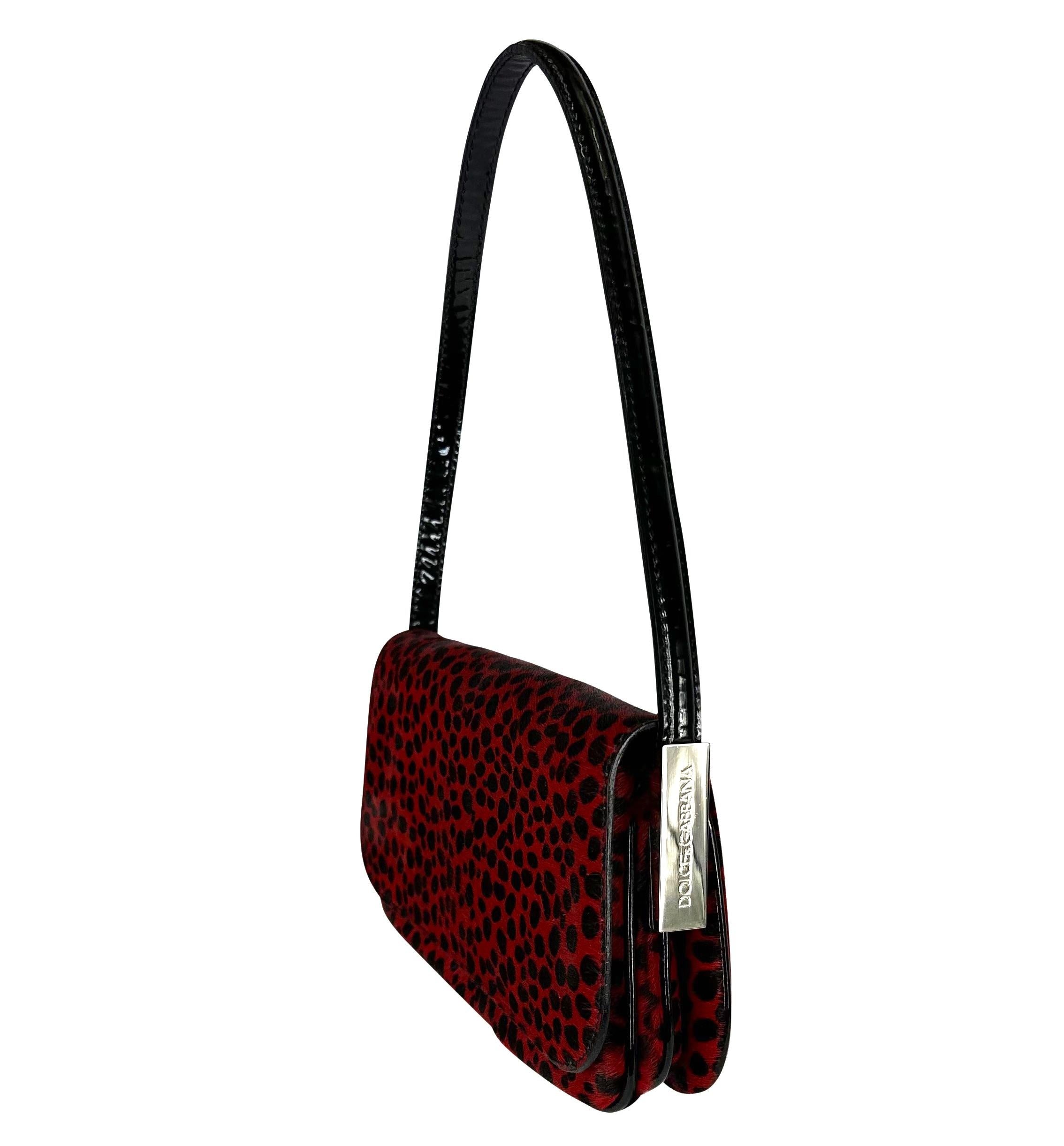Presenting a fabulous black and red zebra print Dolce and Gabbana pony hair convertible shoulder bag. From the Fall/Winter 2000 collection, this beautiful flap bag features silver plate accents at the sides and is the perfect Y2K addition to any