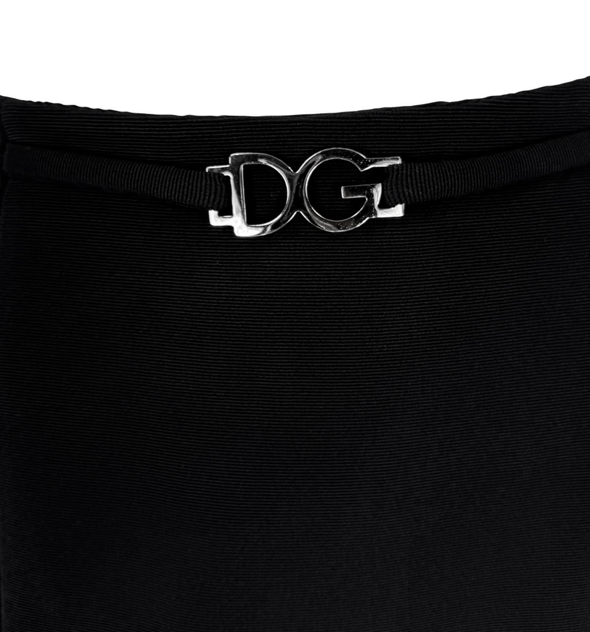Questo set a due pezzi di Dolce & Gabbana degli anni '90 presenta un top con scollo a Rolle e una minigonna coordinata. Fabrice in tessuto nero a costine, il set si chiude in vita con una cintura argentata con fibbia con logo 