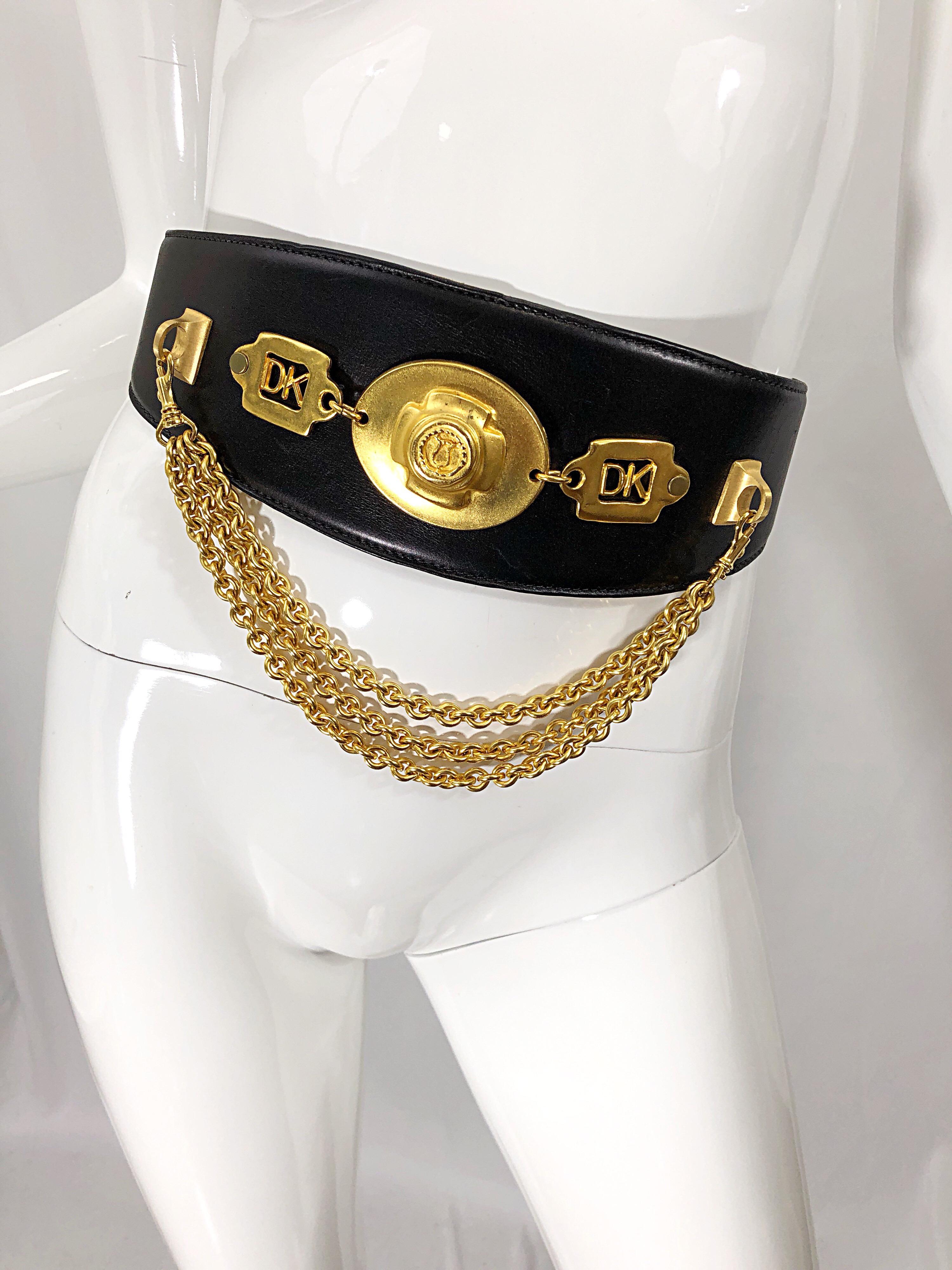 Stylish vintage DONNA KARAN black leather belt with removable gold chains. Gold plaque with the DK logo on each side. The perfect piece to really make an outfit pop! Great with a dress, or over a blouse or tunic. In great condition. 
Made in