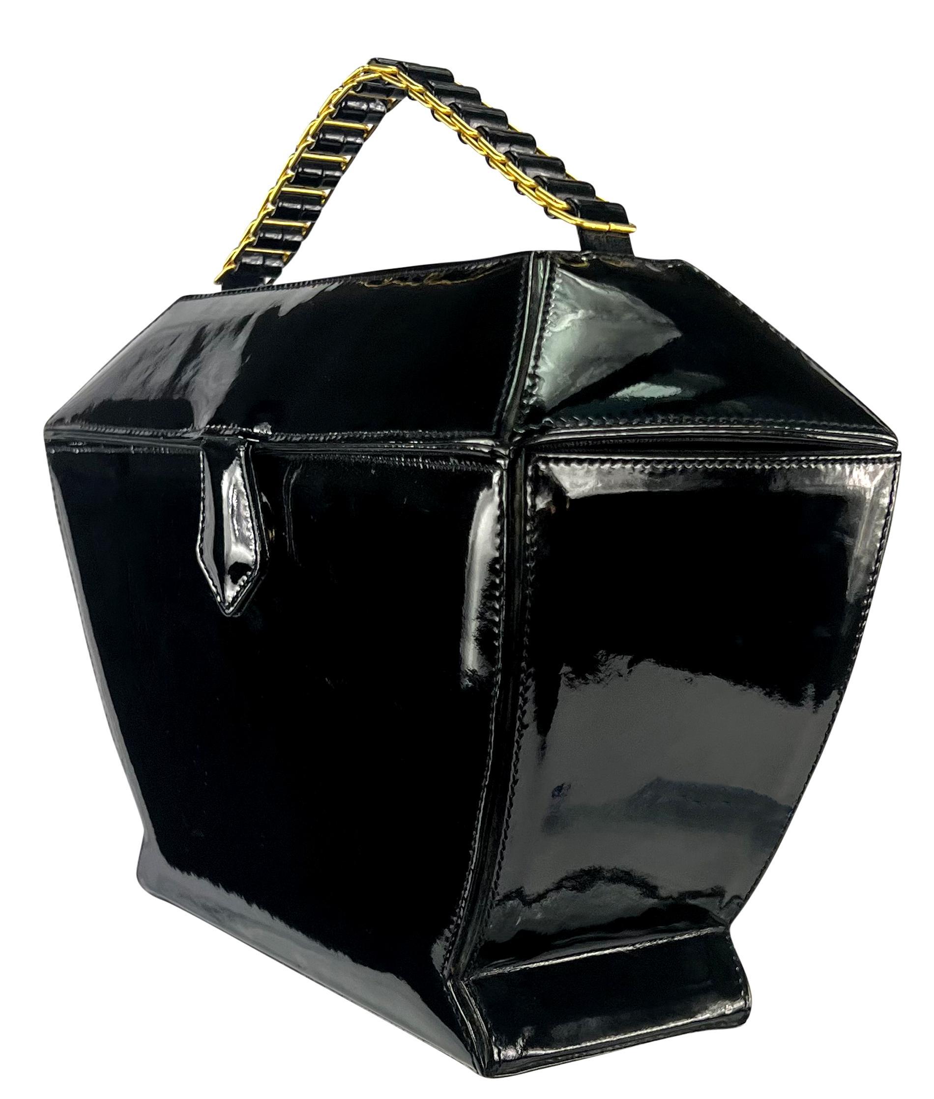 From the 1990s, this structured black patent leather Donna Karan bag is a chic and unique addition to any modern wardrobe. With an urn-like silhouette, this top handle bag is accented by a gold-tone link handle and a magnetic closure.

Approximate