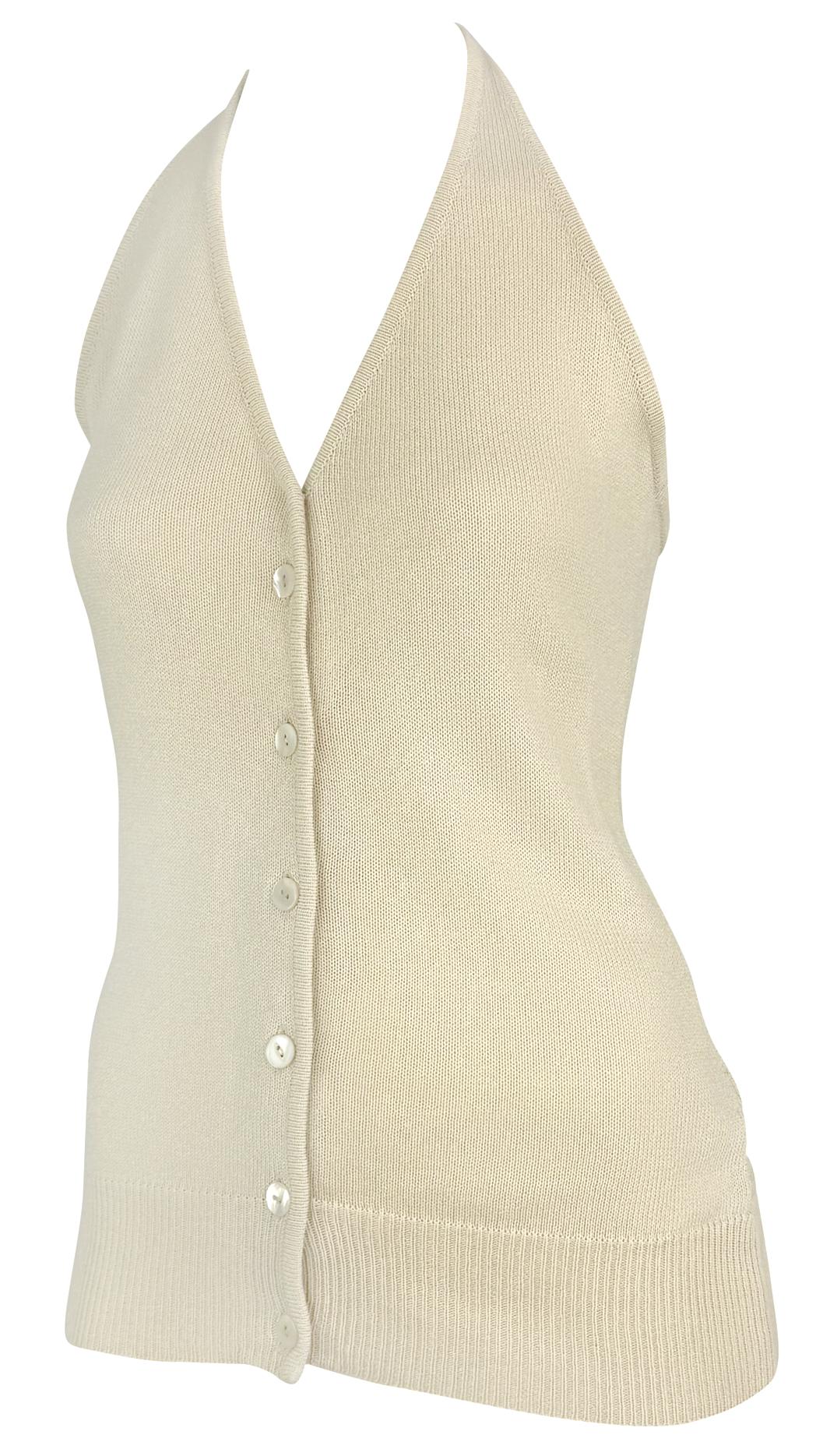 This 1990s Donna Karan halter top is crafted from a semi-sheer off-white stretch knit. The design features a deep V-neckline, a button-up front, and a ribbed hem, offering a sleek, form-fitting silhouette.

Approximate measurements:
Size - S
Bust: