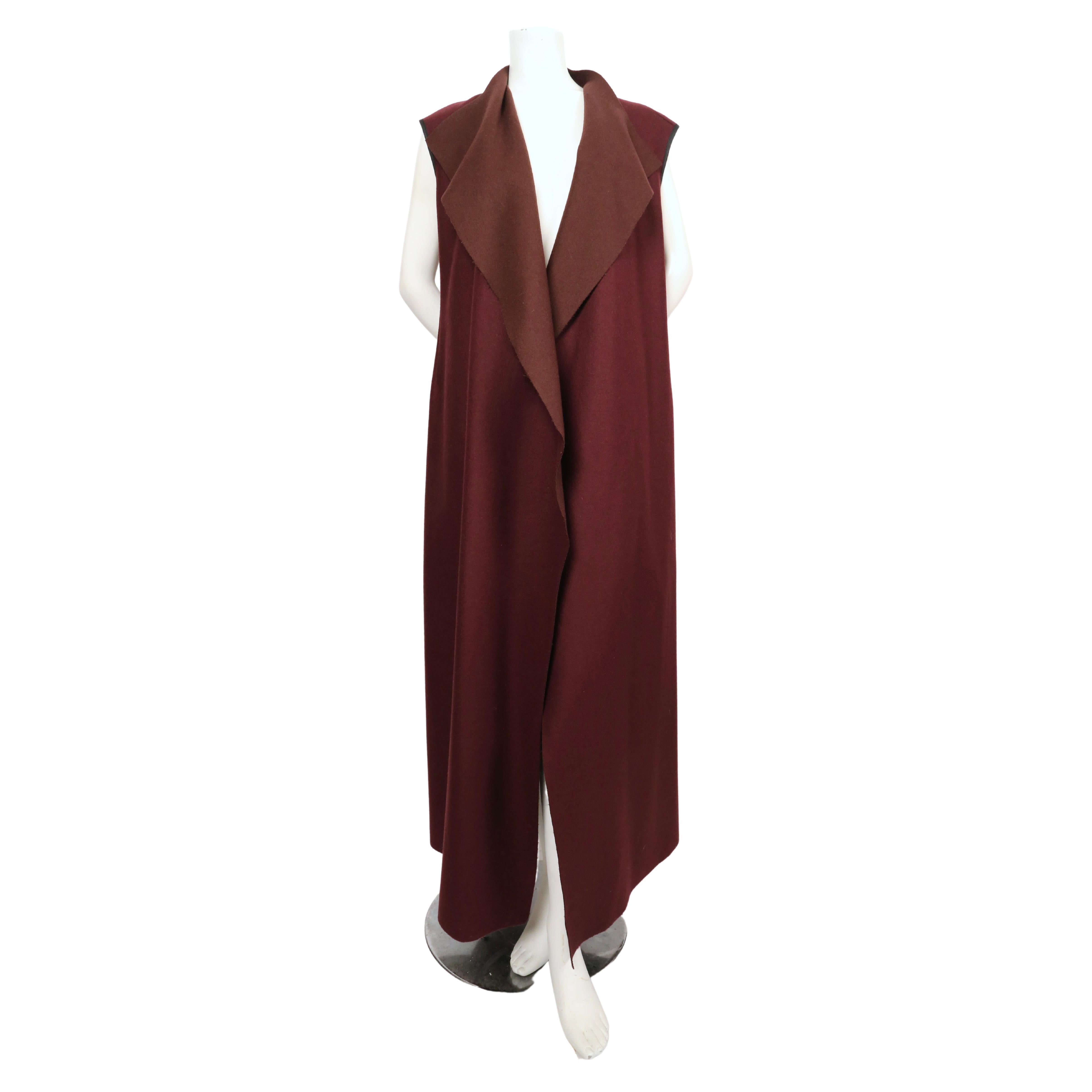 Dramatic, maxi-length, sleeveless wool coat with open closure from Dries Van Noten dating to the early 1990's. French size 38. Approximate measurements: shoulder 18