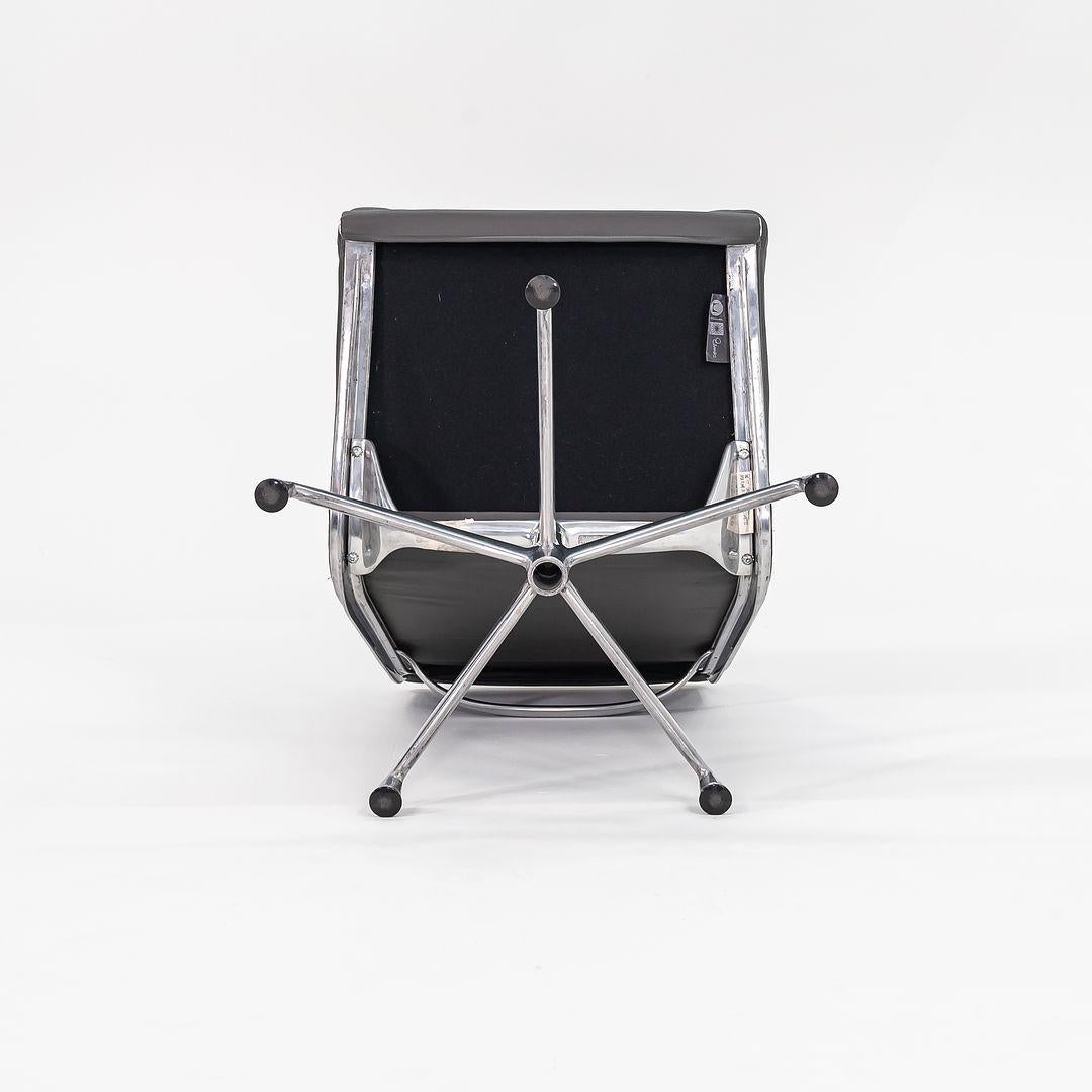 Se trata de una Silla Eames Aluminum Group Soft Pad Lounge y su correspondiente Otomana, modelos EA414 y EA223, diseñados originalmente por Charles and Ray Eames en 1969. Estas piezas datan de la década de 1990 y se han vuelto a tapizar en cuero
