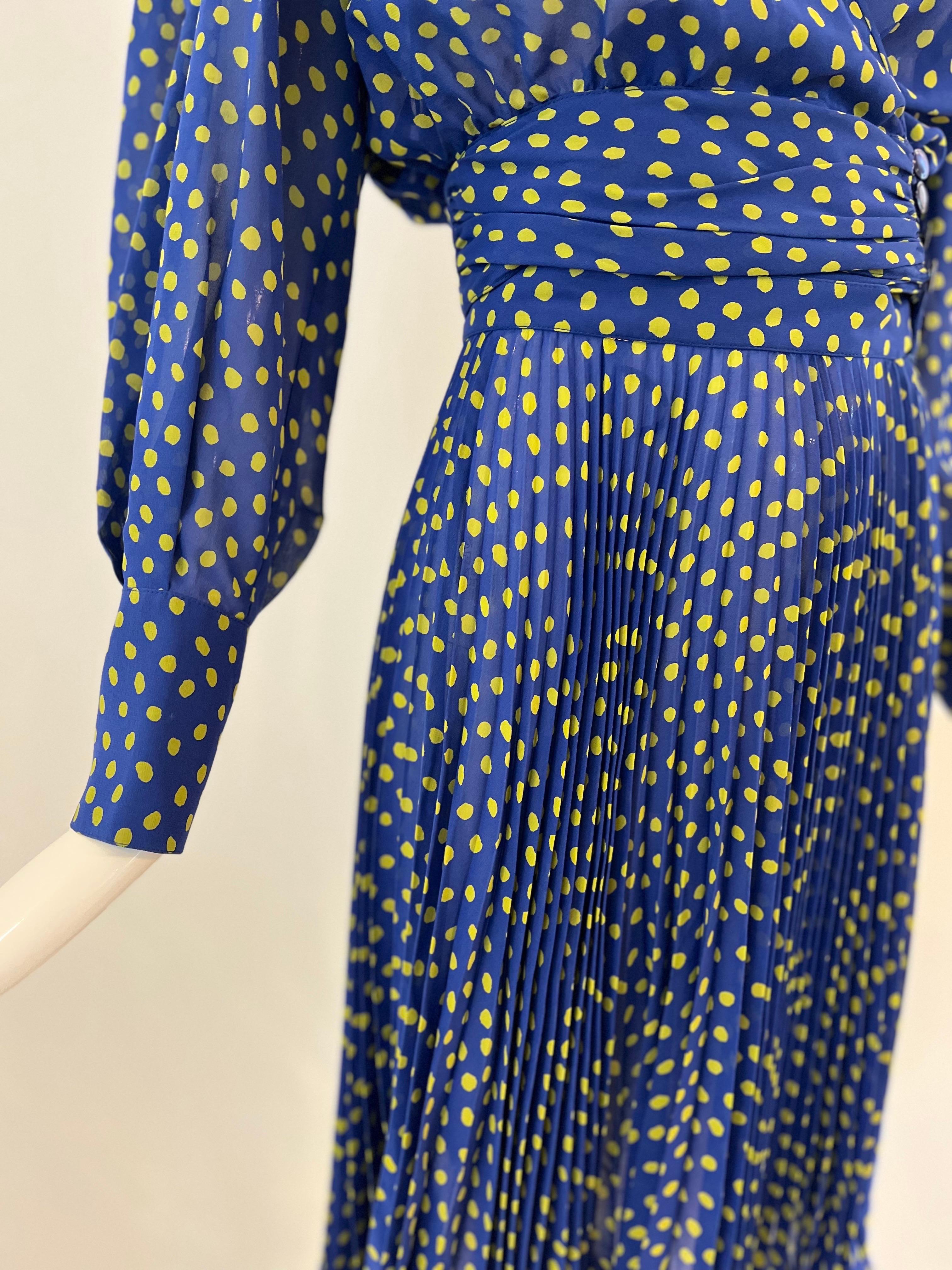1990s Ungaro flirty little two piece polka dot set in an electric blue with yellow dots.  A full pleated skirt is matched with a wrap top, ruched at the waist with four resin button closure and balloon sleeves with long button cuffs.  The beauty of