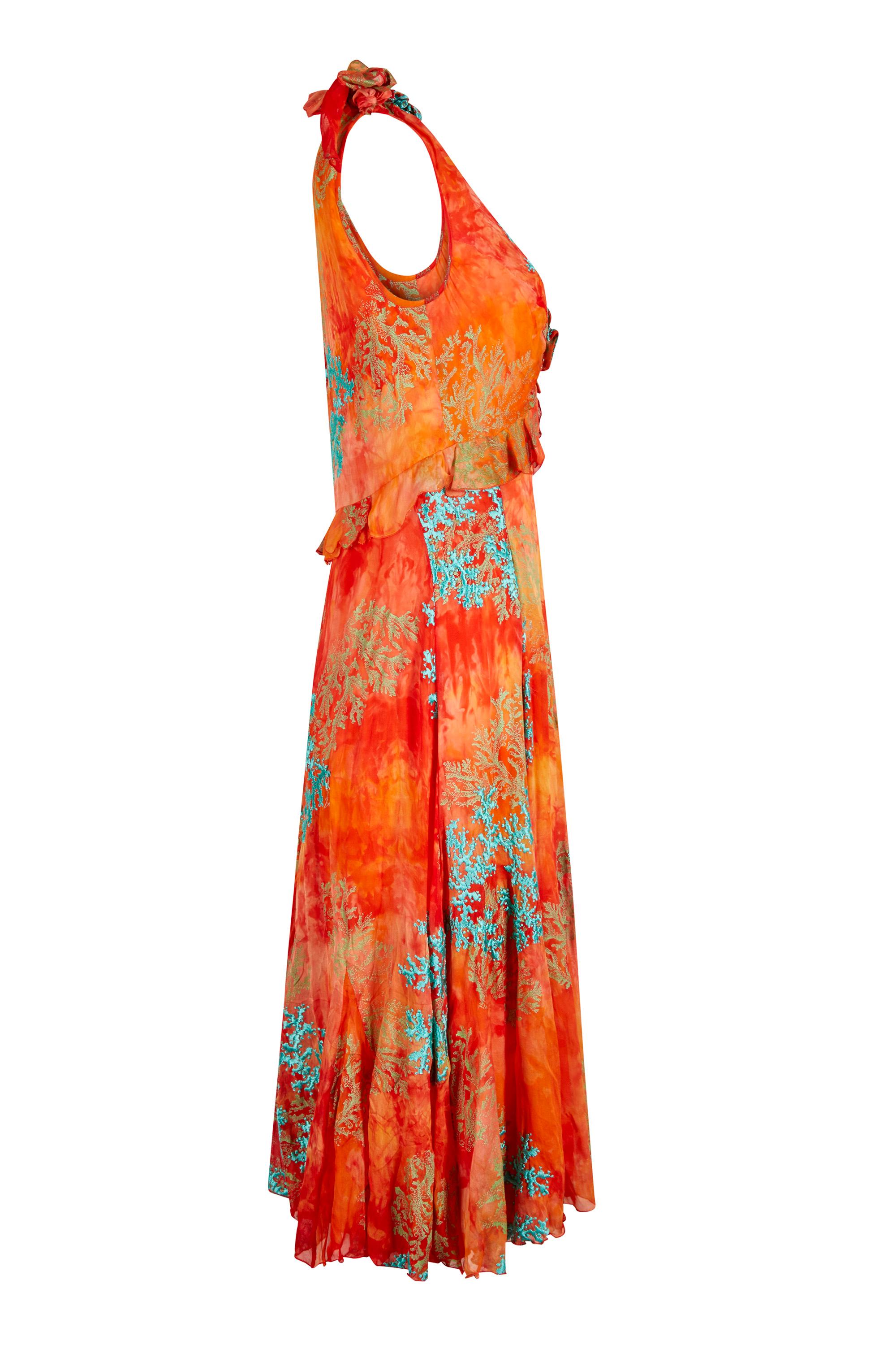 This sensational 1990s embroidered silk chiffon couture set is comprised of a dress and clutch bag in matching fabric. The fabric is a vibrant tangerine which has been tie dyed to create a textured effect in a slightly lighter shade. It has then