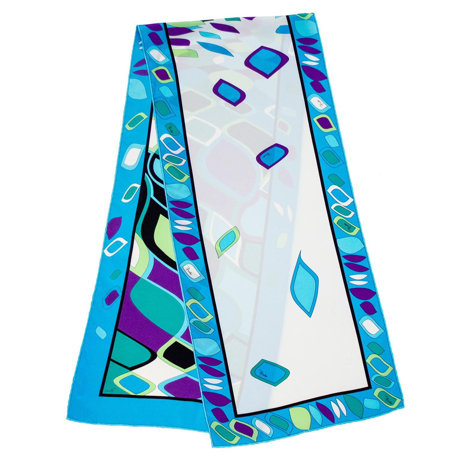 Narrow Emilio Pucci silk scarf from the 1990s with a classic Pucci abstract geometric print. Shades of blue, green and purple. The centre features a distorted geometric print that fades into a few floating shapes on the white background on one side.