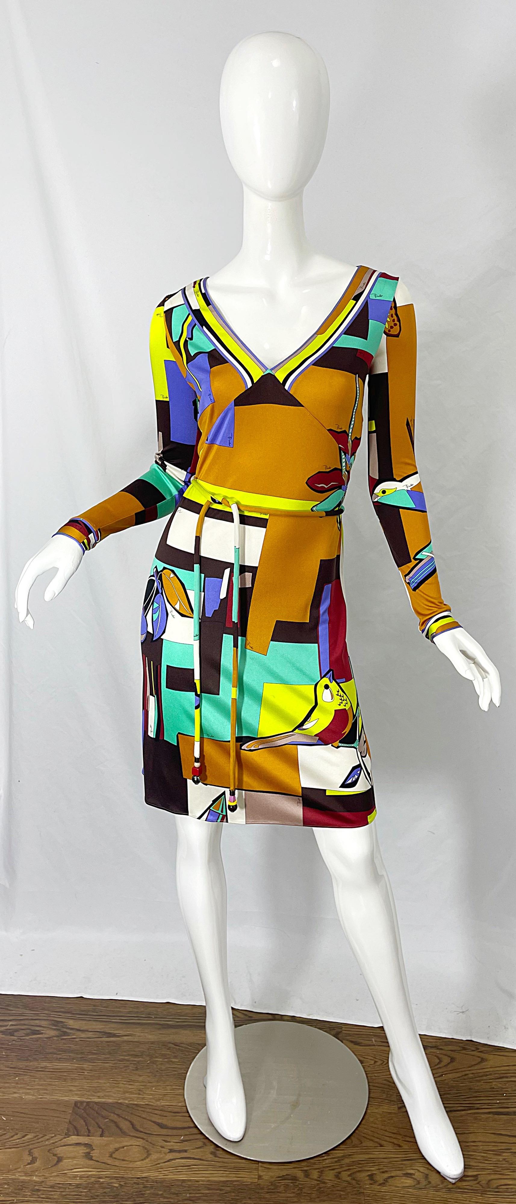 Amazing 1990s EMILIO PUCCI novelty bird, butterfly, and dragonfly print silk jersey long sleeve belted dress ! Features a tailored v-neck bodice with a slinky skirt. Vibrant colors of turquoise blue, purple, neon green, white, black and terra cotta.