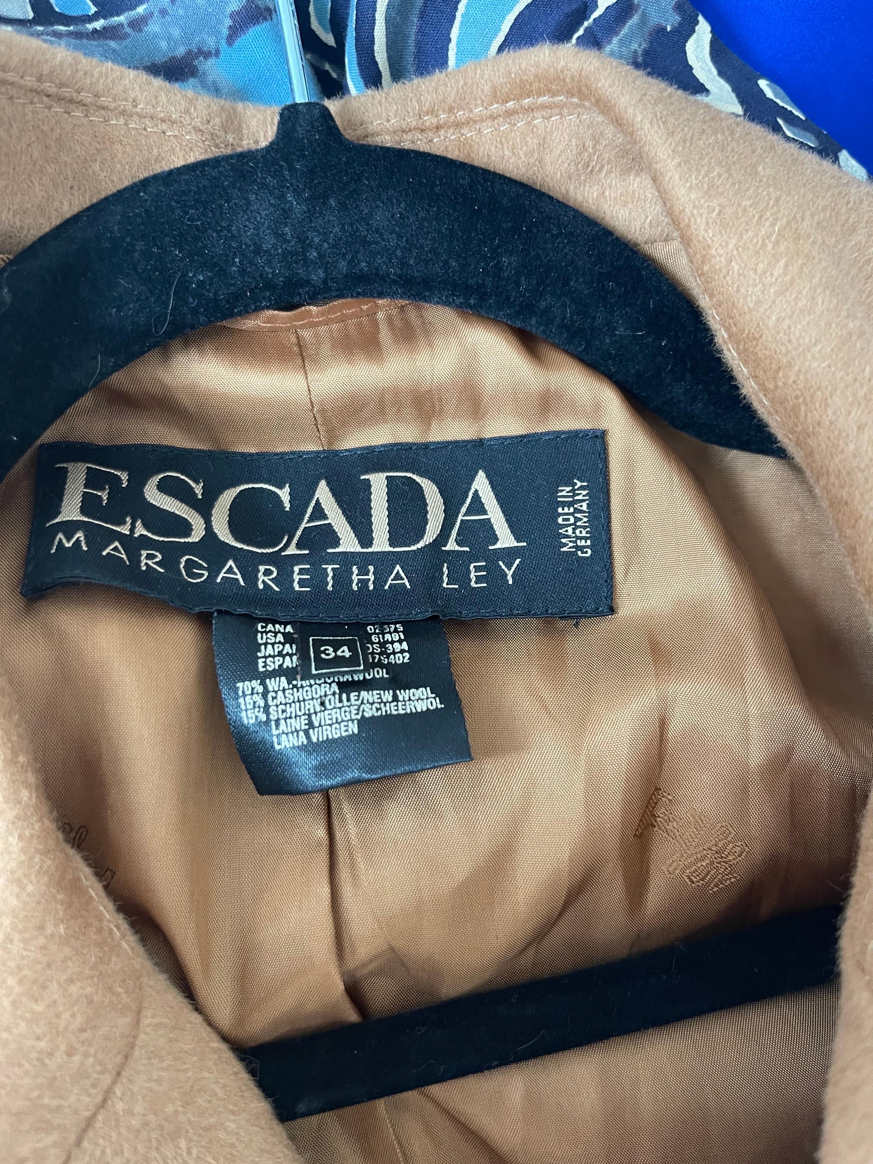 Chic 1990s Escada by Margaretha Ley camel cashmere, wool and virgin wool double breasted blazer jacket ! Model is US Size 6. Features gold buttons up the front and at each sleeve cuff. Fully lined. 
The pictured vintage MERCURA NYC flying monkey
