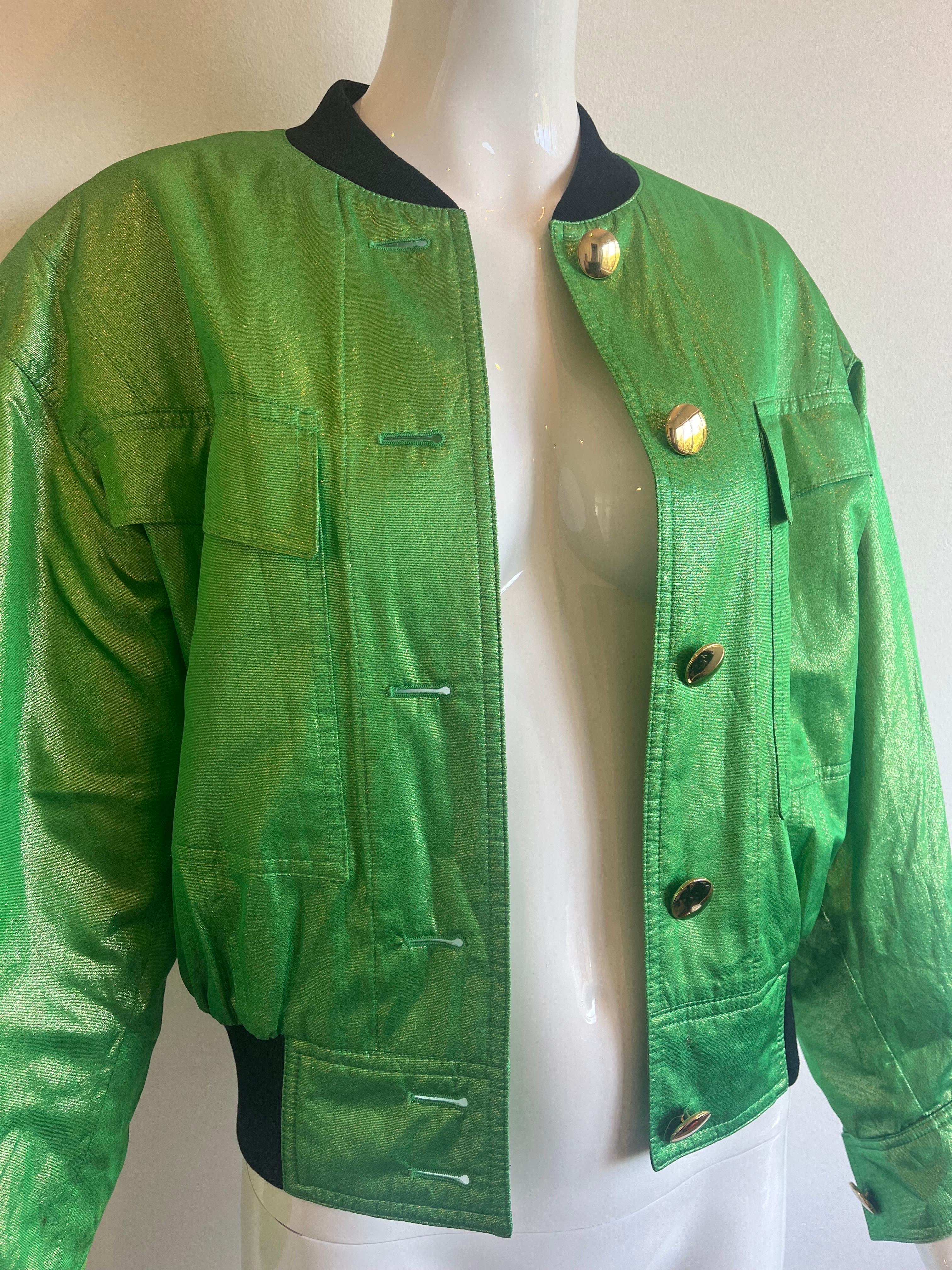 Funky 1990s Escada bomber jacket in an eye catching green metallic outer fabric with big gold button closure.  The inside lining is a pop art heart print in green and bright colors.  The cuffs and waist are a stretchy soft sweatshirt band material. 