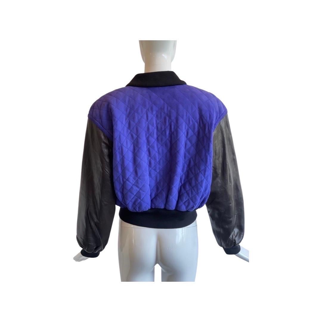 Too cool for school! 1990s Escada bomber jacket in a royal blue quilted suede with soft black leather arms and sweatband material waist band.  Big black pop buttons and two zipper pockets at the chest and a cotton contrast collar.  Some light fading