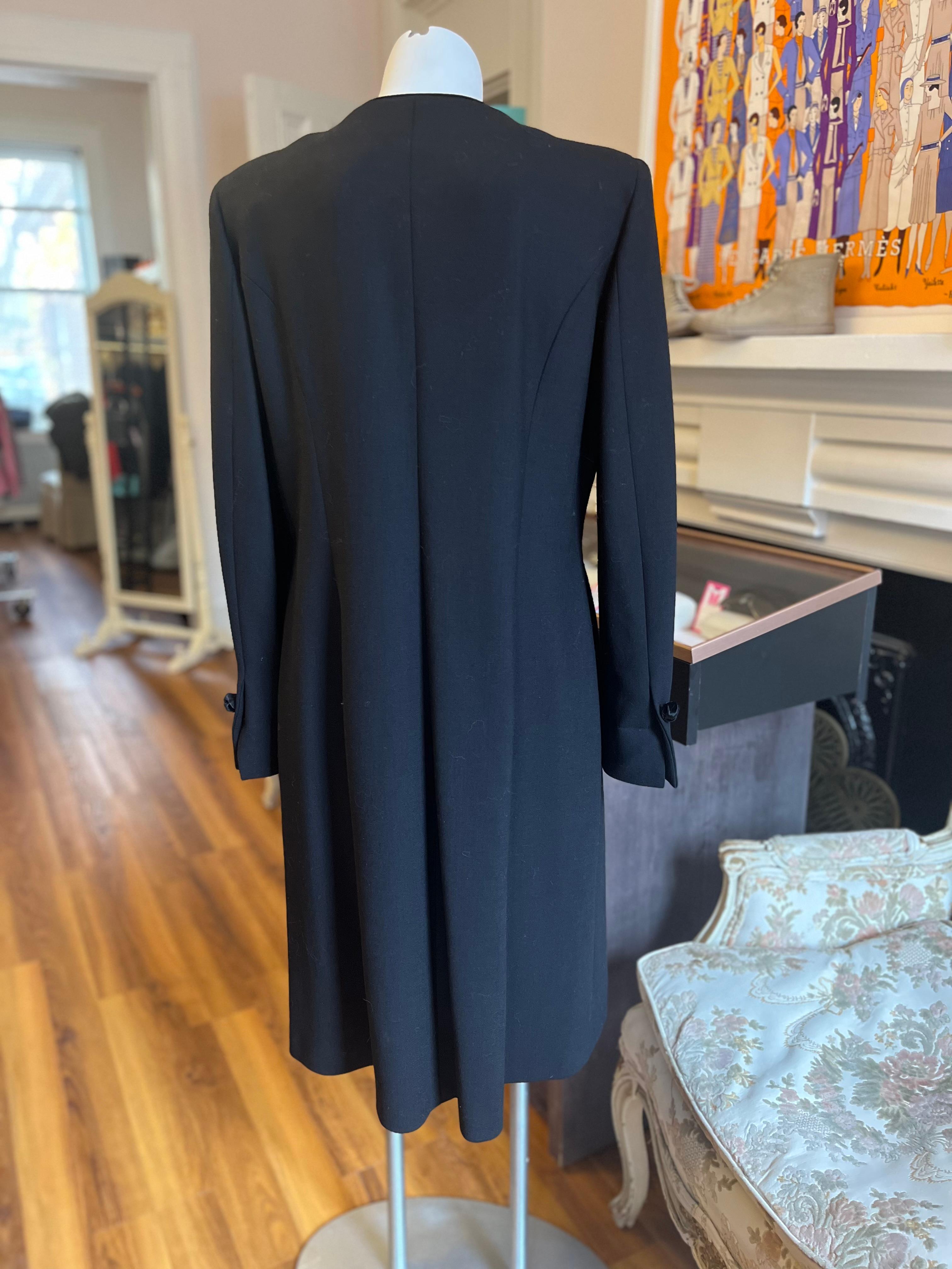 This is a Fendi 365 coat from the 1990s which is in as new condition. It is made of 75% wool 10% viscose, 10% rayon and 5% silk. The coat is trimmed with black velvet and there are ornamental velvet knot buttons, both at the front and on the cuffs.