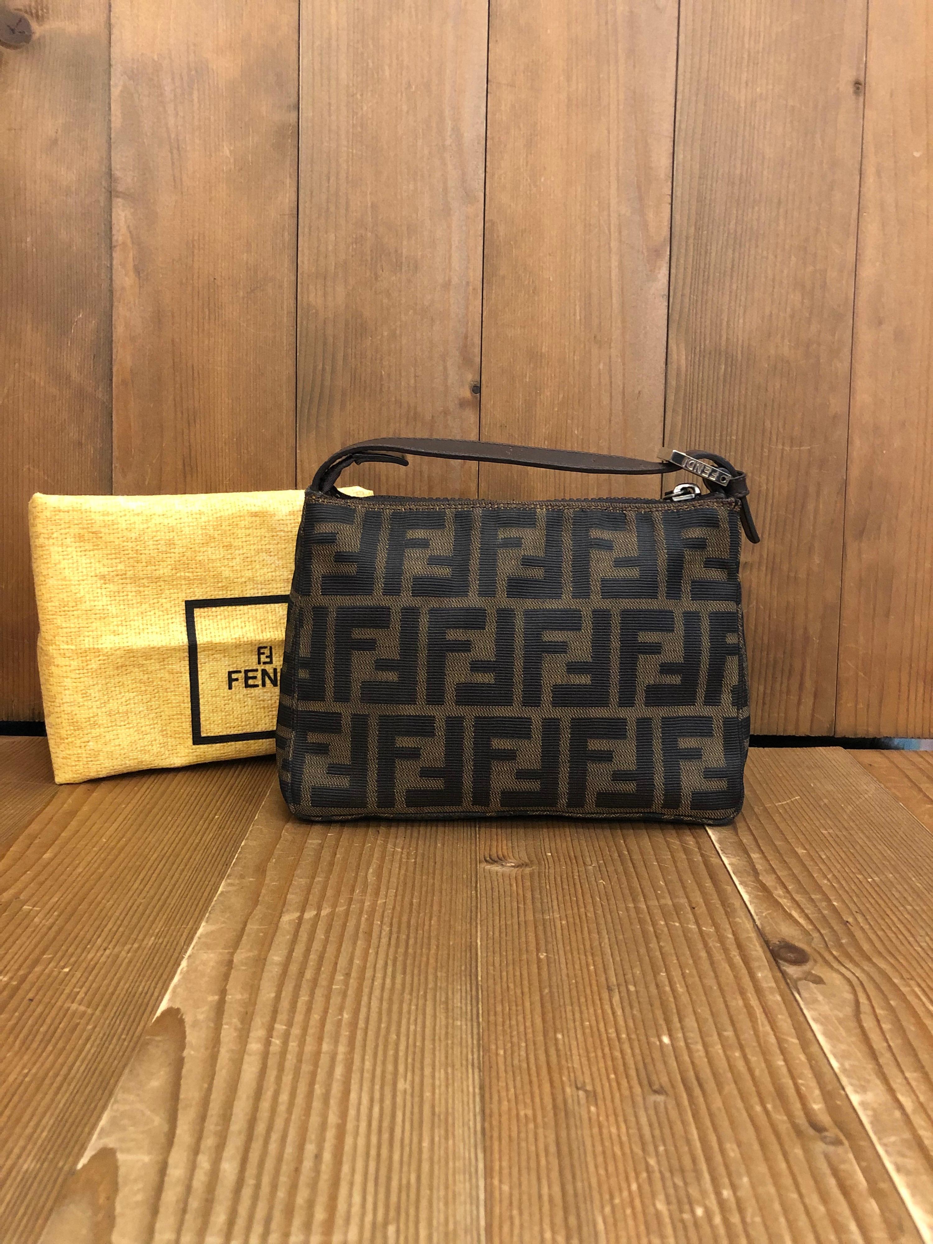 Vintage Fendi mini pouch handbag in Fendi's iconi Zucca jacquard. Zipper top closure. Made in Italy. Measures 7.5 x 5.25 x 3.25 inches (fits plus-sized iPhone). Comes with dust bag.

Condition: Minor signs of wear on exterior. Interior fully
