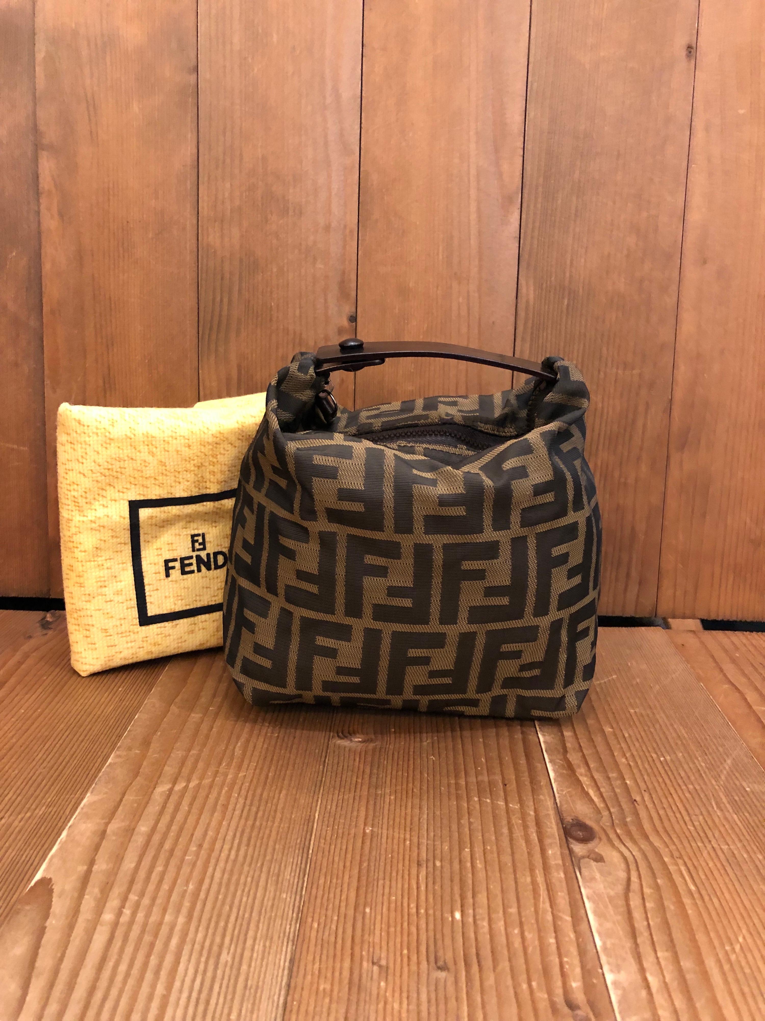 Vintage Fendi mini pouch handbag in Fendi's iconic brown Zucca jacquard. Zipper top and snap closure. Made in Italy. Measures 6.5 x 6 x 4.25 inches (fits plus-sized iPhone). Comes with dustbag.

Condition: Minor signs of wear. Generally in very good