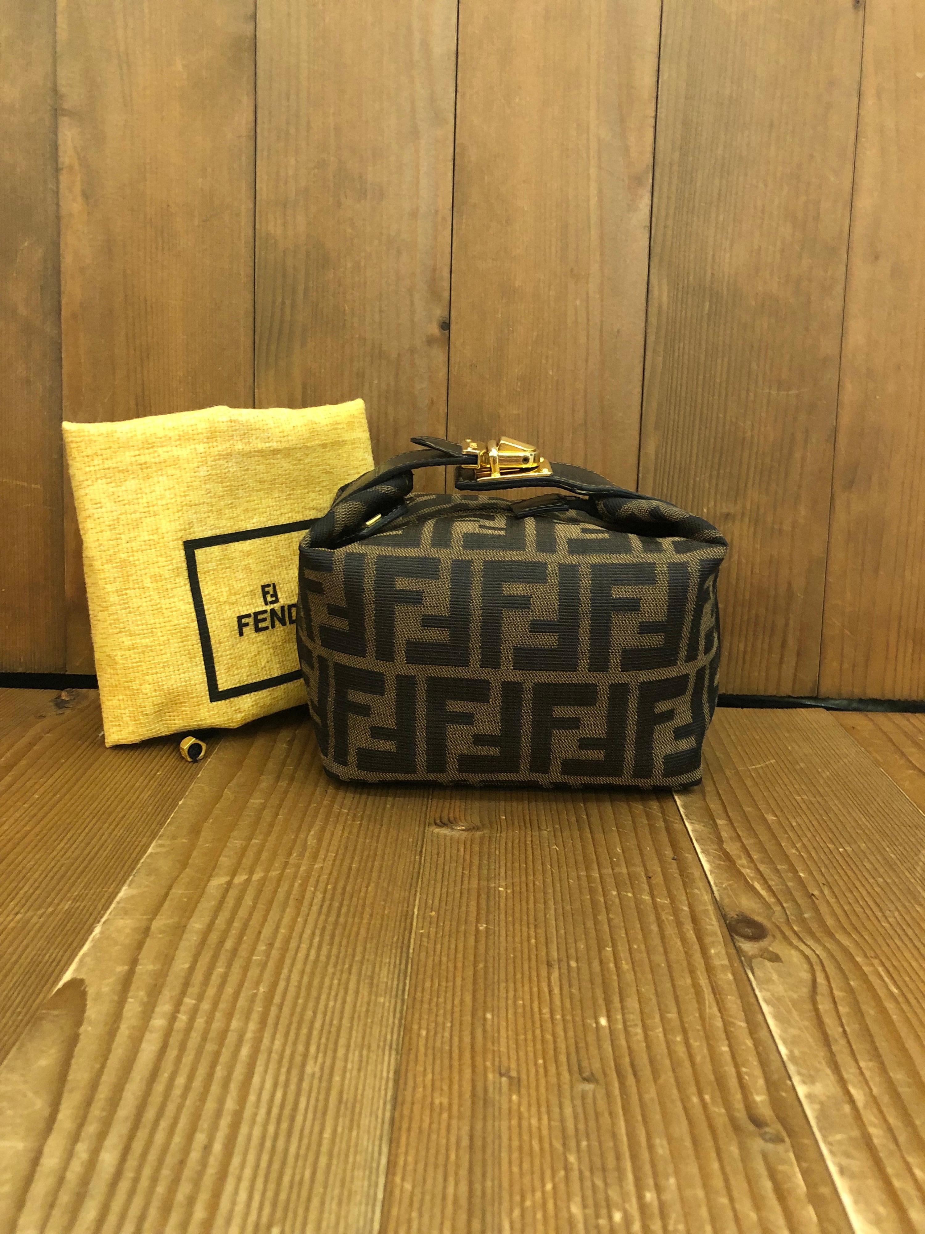 Vintage Fendi mini vanity pouch in Fendi's iconic Zucca jacquard featuring gold toned buckled handle. Made in Italy. Measures 6 x 5 x 3.75 inches (fits plus-sized iPhone)

Condition: Minor signs of wear. Generally in good condition.

Outside: Minor