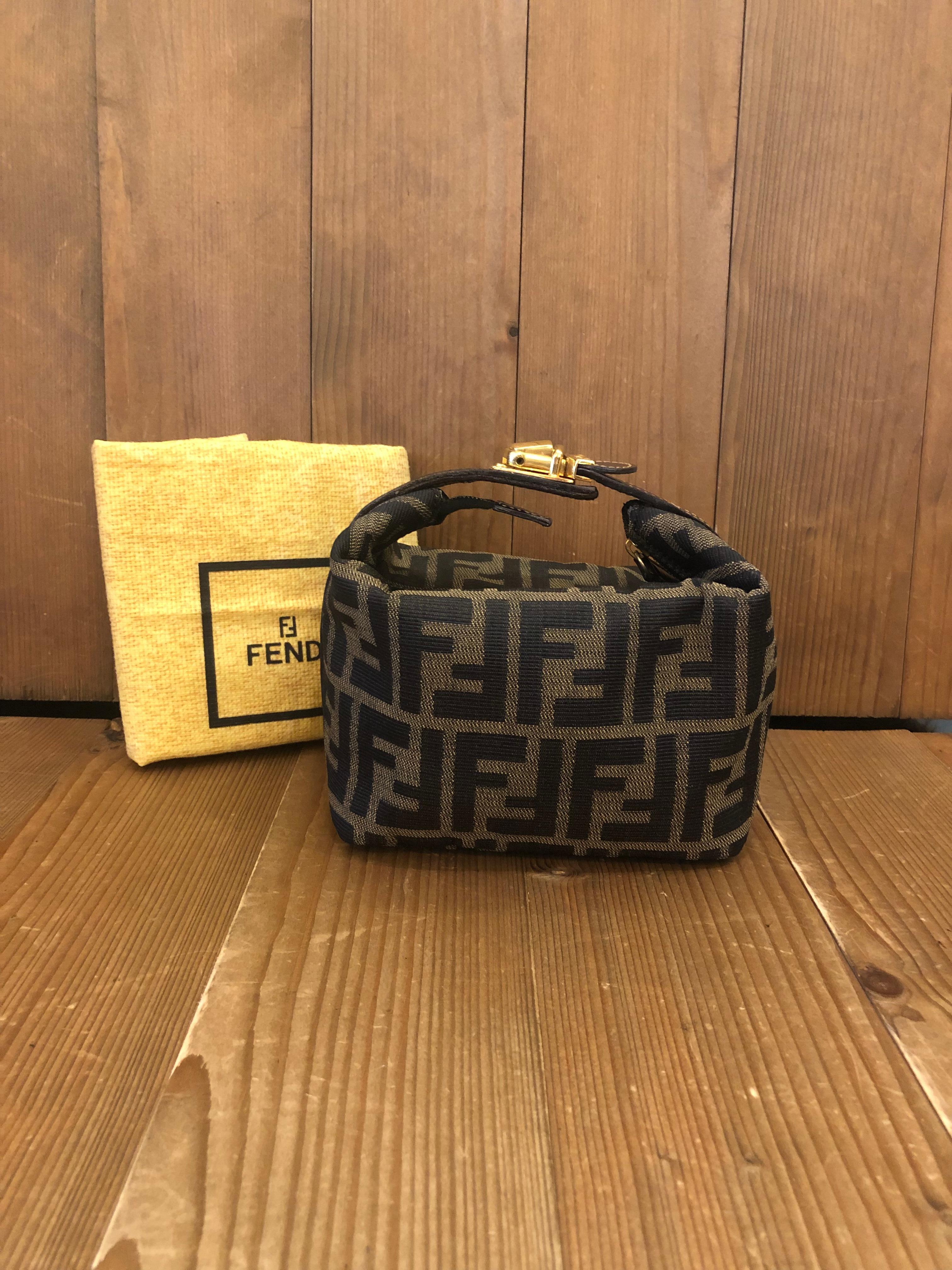 Vintage Fendi mini vanity pouch in Fendi's iconic Zucca jacquard featuring gold toned buckled handle. Made in Italy. Measures 6 x 5 x 3.75 inches (fits plus-sized iPhone)

Condition: Minor signs of wear. Interior fully re-lined

Outside: Minimal