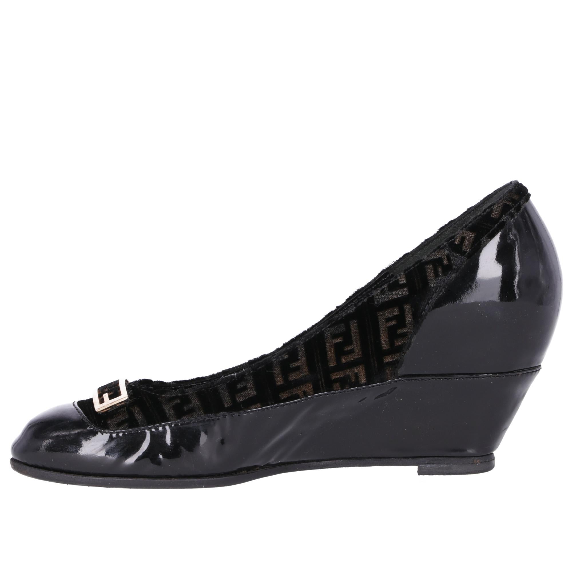 Fendi decolleté with wedge, in black patent leather with logoed velvet on the upper part of the upper, round toe and golden metal logo applied.

The item shows slight signs of wear on the metal part and on the velvet, as shown in pictures.

Years: