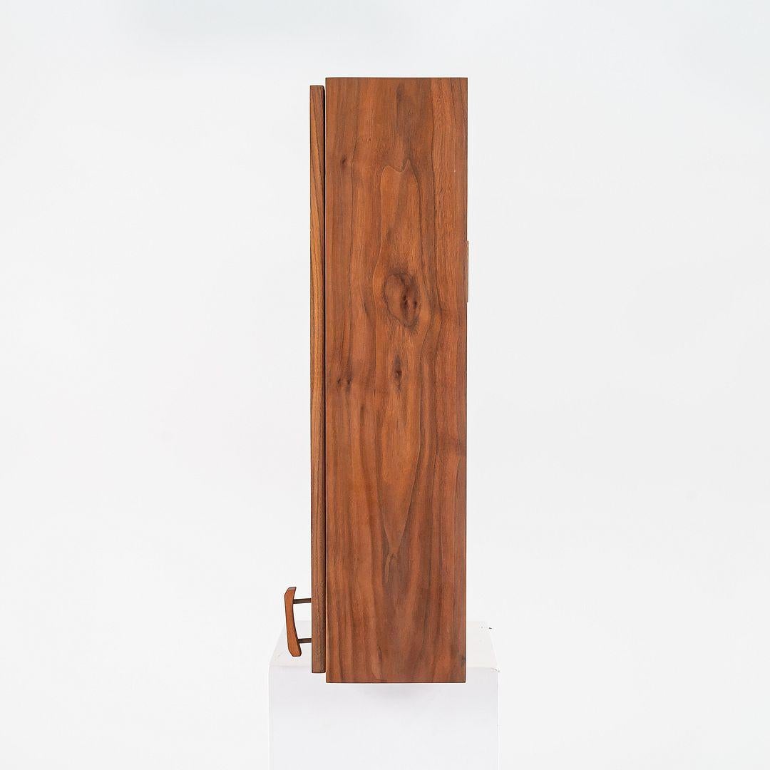 This is a custom made medicine cabinet, made by a woodworker in New Hope, PA and produced in the 1990s. The design is comprised entirely of walnut. 

The medicine cabinet measures 9 inches deep, 18 inches wide, and 30 inches tall. The interior has a