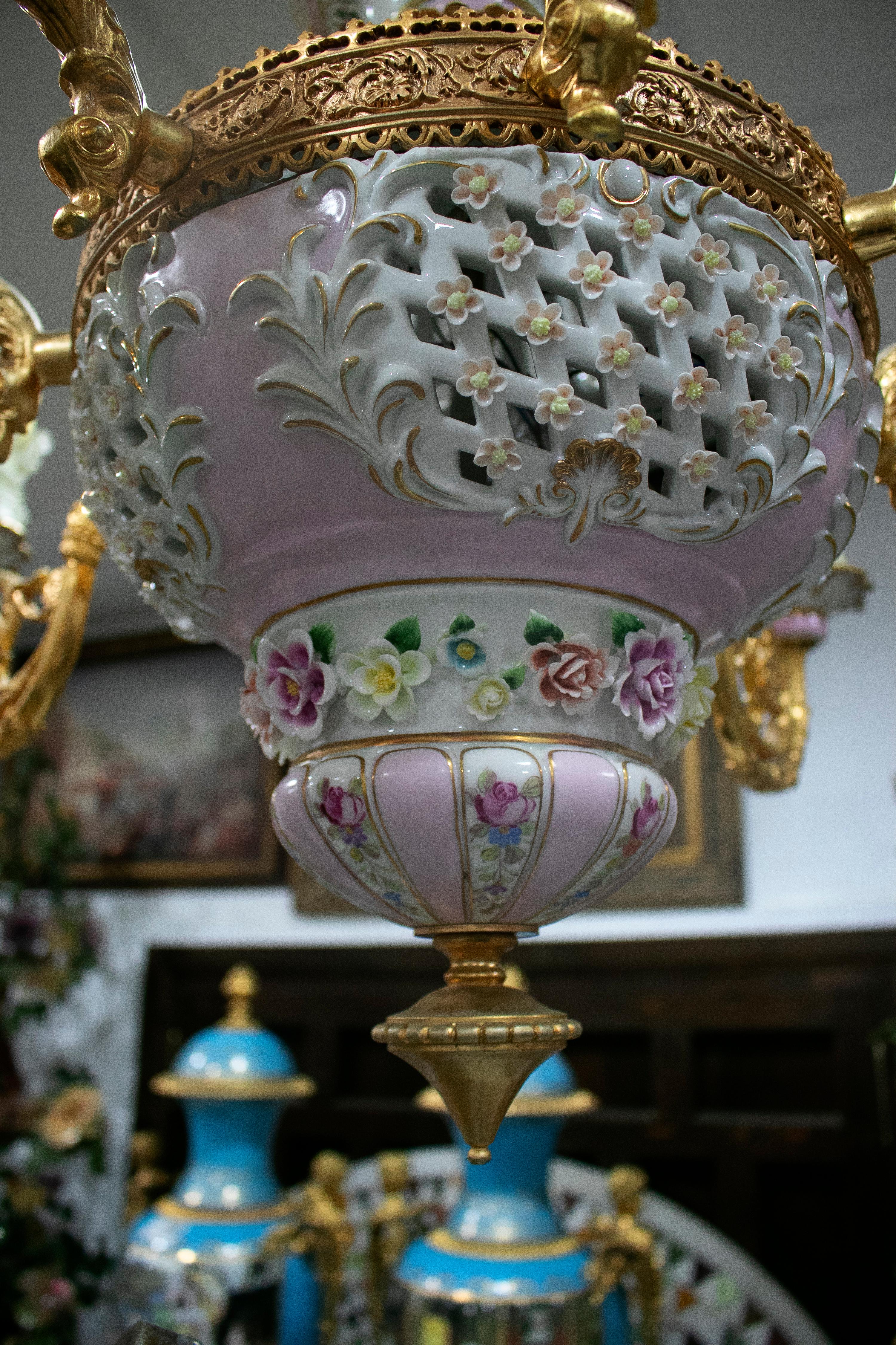 Ornate 1990s French white and rose pink hand painted porcelain chandelier with 8 golden bronze arms and hanging glass ornaments.

 