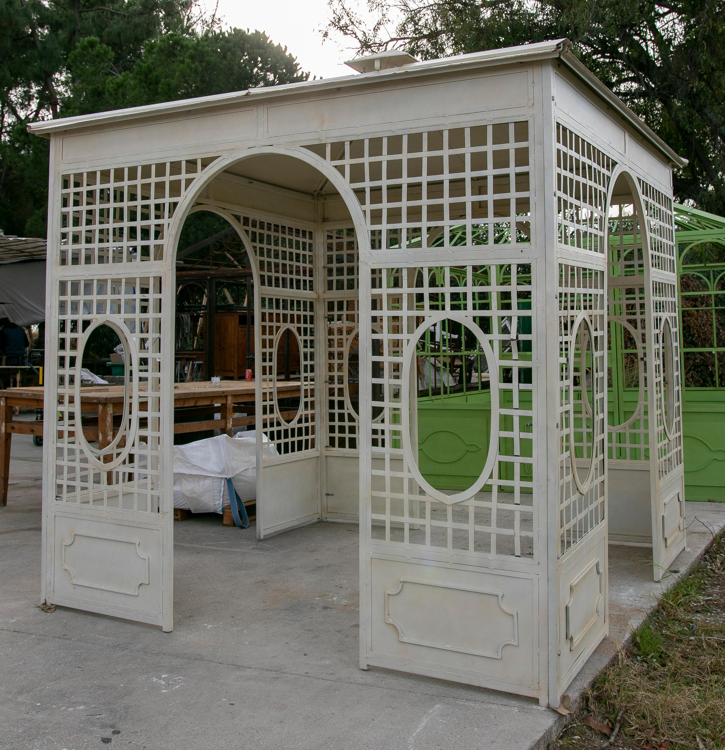 Traditional 1990s French square iron garden greenhouse painted white, open on four sides.
 