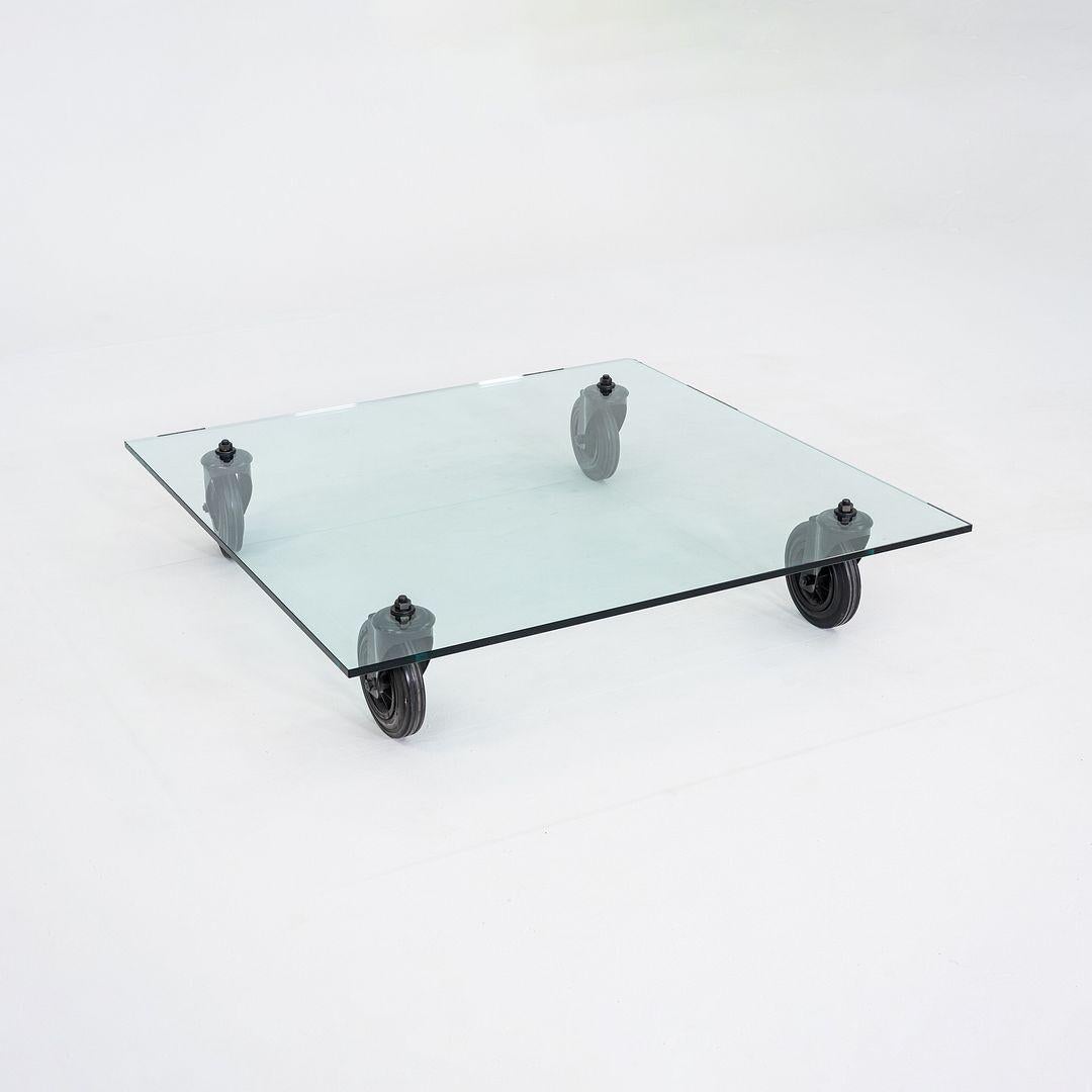 Il s'agit d'une table basse Tavolo Con Ruote, conçue à l'origine par Gae Aulenti pour Fontana Arte en 1980. Cet exemple particulier a été produit en Italie et date des années 1990. La table présente un plateau en verre épais reposant sur quatre