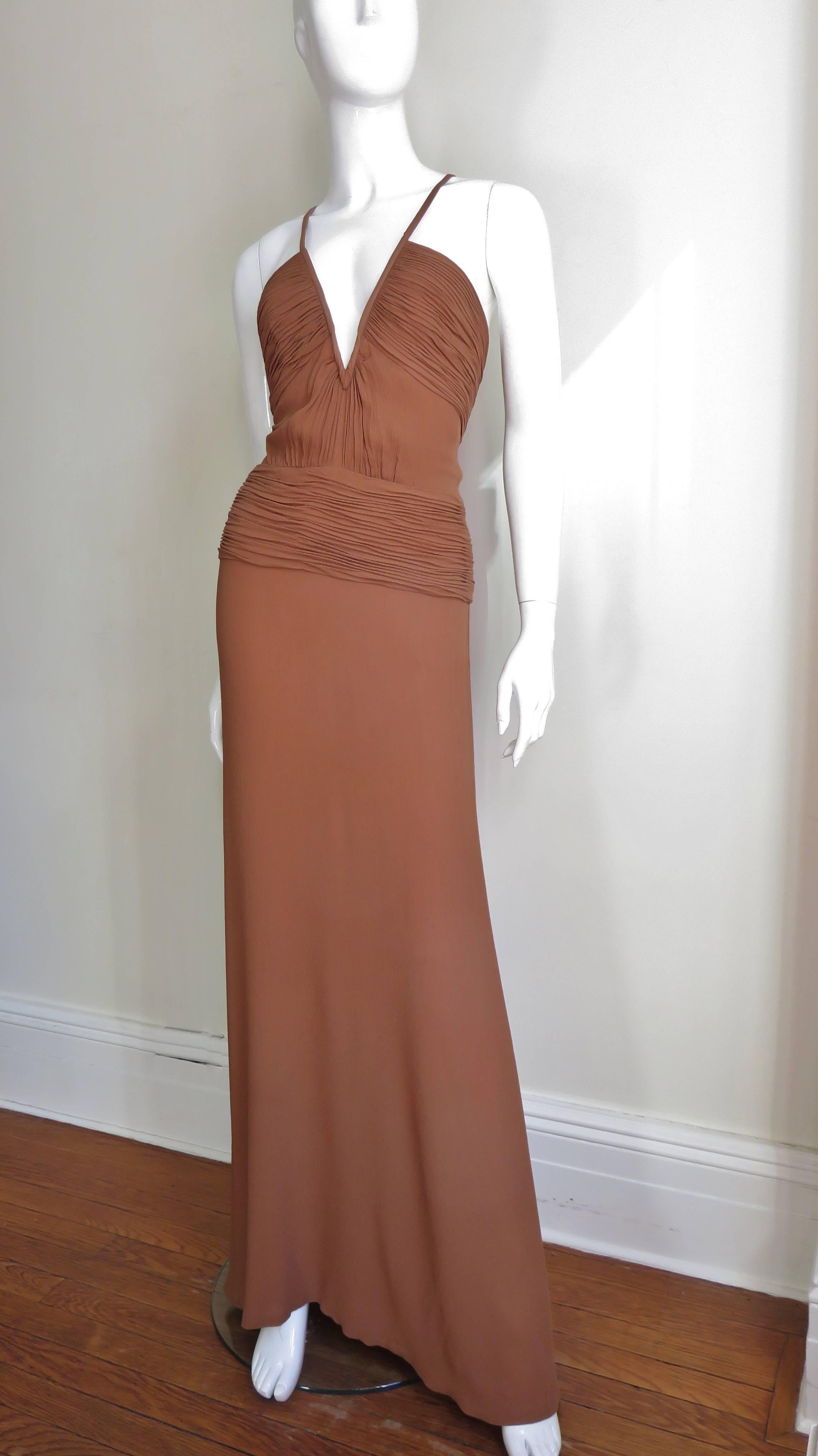 A gorgeous tan brown silk gown from Gianni Versace Couture. It has a V neckline with spaghetti straps, ruched panels across the bust and another around the waist and hips. The skirt portion is slightly fuller below the knee in the front and fuller