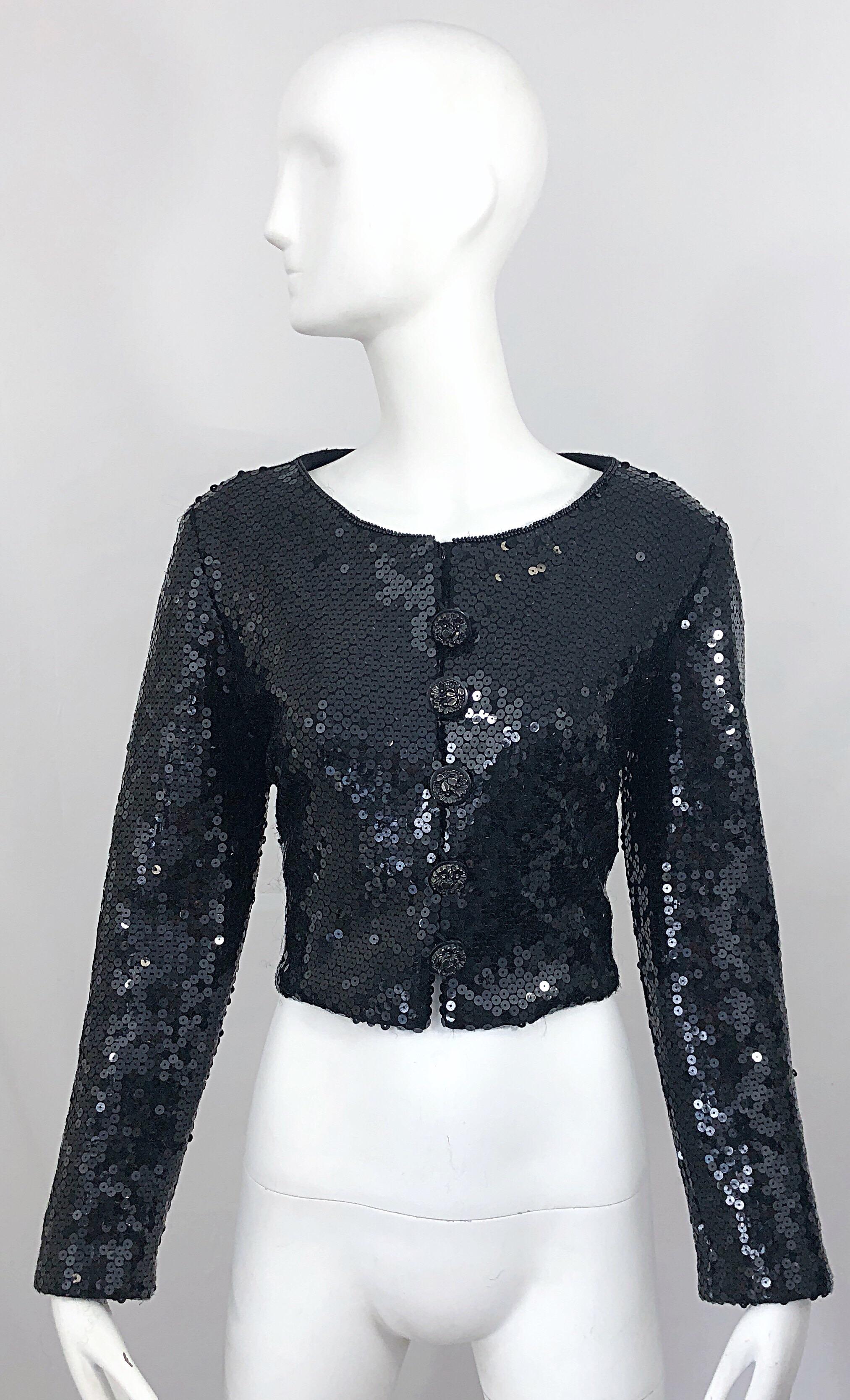 Chic 1990s GEMMA KHANG black sequined wool crop jacket. Features thousands of hand-sewn black sequins throughout. Large silver /gunmetal nickel flower etched buttons up the front. Black seed beads along the collar. Soft wool back. Perfect smartly