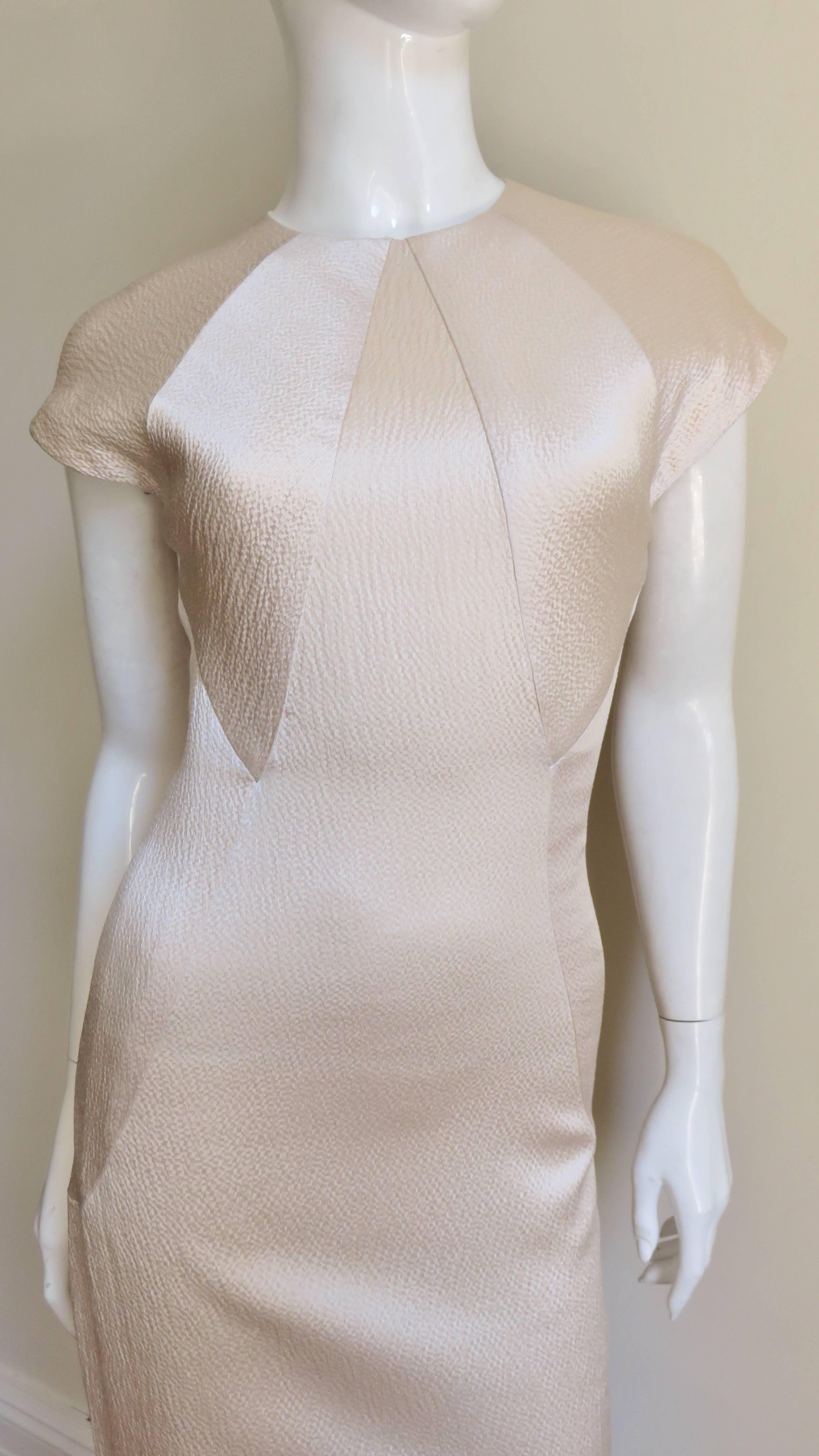 A gorgeous blush pink silk dress from Geoffrey Beene. It is semi fitted with cap sleeves and has angular seaming radiating from the crew neckline.  It is fully lined in matching silk, has button closing at the upper back and an invisible zipper
