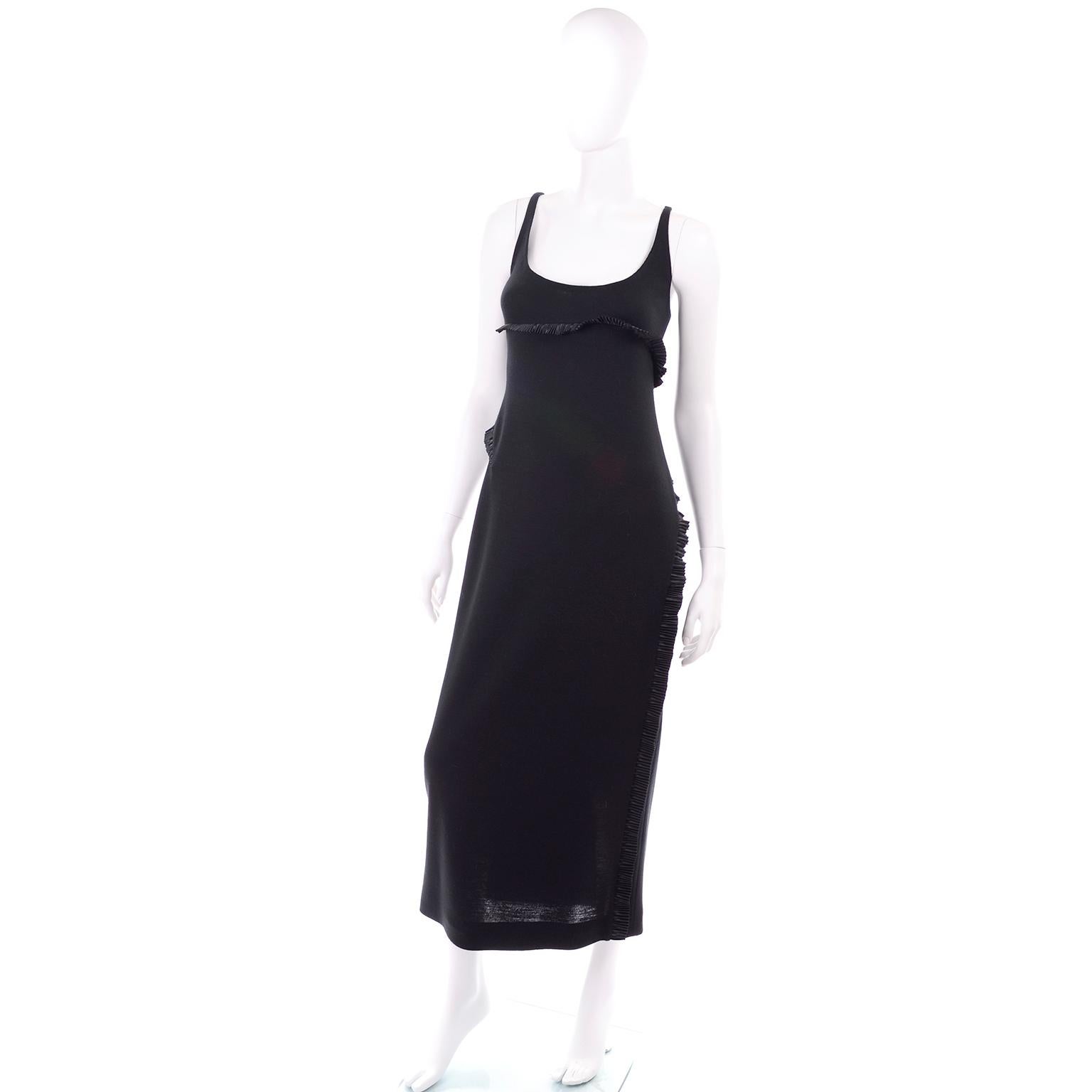 This is a two piece vintage black alpaca dress and coat ensemble from Geoffrey Beene from the Fall 1999 collection. This outfit includes a midi length black dress with a low scoop neck thin straps and diagonal pleated satin bands that are similar to