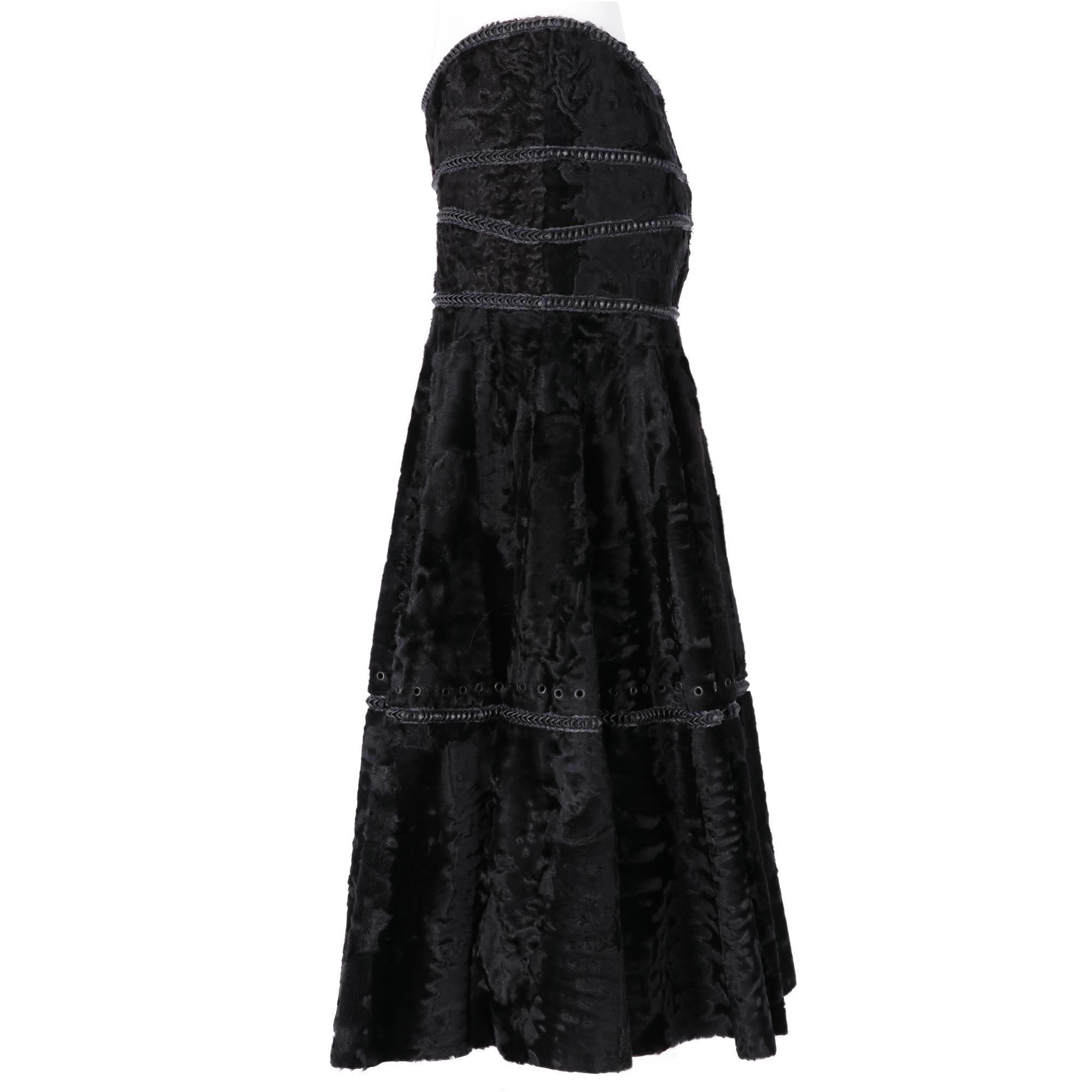 Gianfranco Ferrè long high-waisted skirt, tight to the pelvis and flared on the bottom, in black astrakhan fur, with decorative inserts in black leather and metal rivets, on the front there is a black metal logoed plate, closure on the back with zip