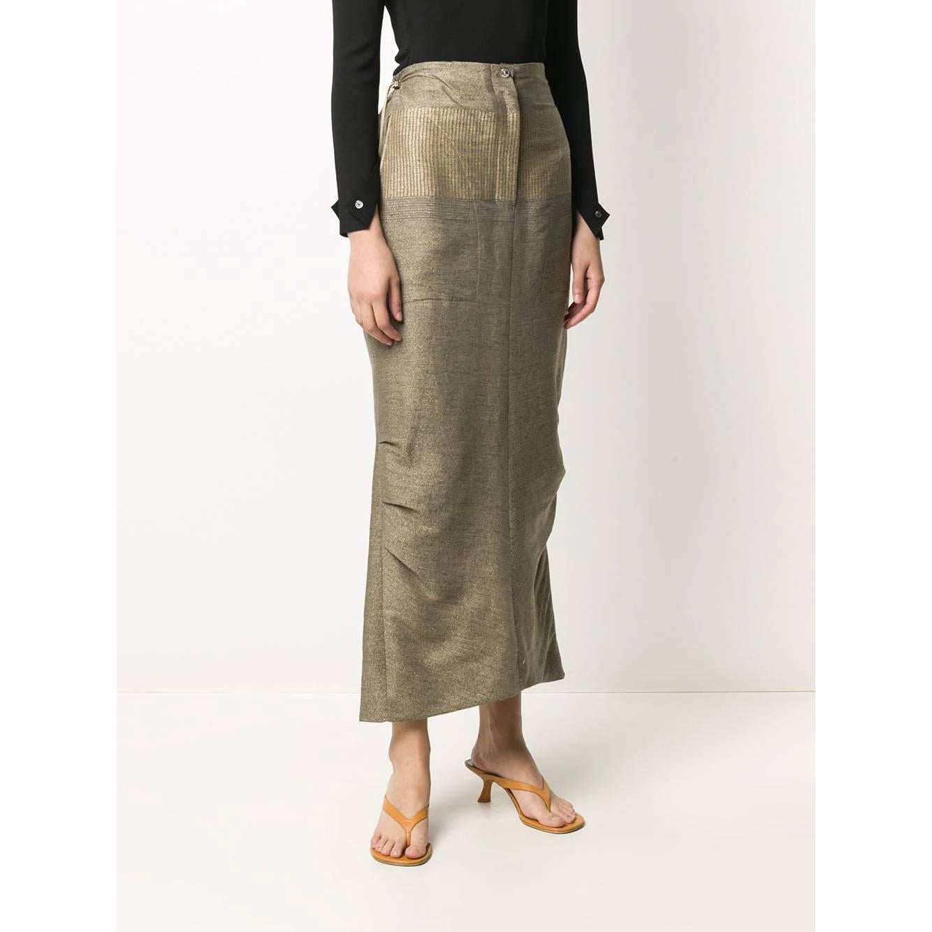 A.N.G.E.L.O. VINTAGE - Italy
Gianfranco Ferré gray and gold cotton skirt. Straight model with high waist. Front closure with button and zip and adjustable drawstring at the waist. Side drapes and back vent.

This item belongs to a deadstock, it has