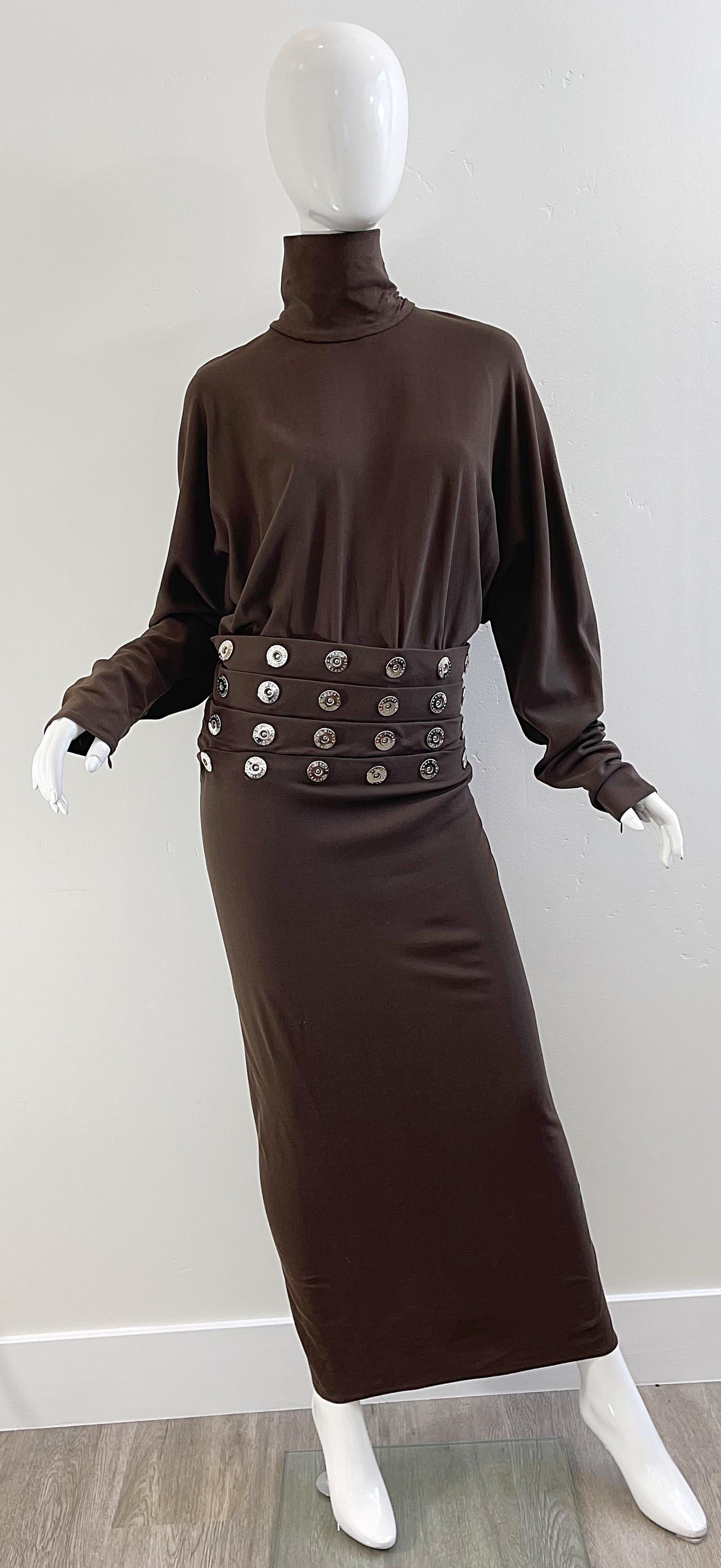 Chic 1990s vintage GIANFRANCO FERRE chocolate brown silver grommet encrusted rayon elastane turtleneck evening dress ! Features logo embossed grommets at drop waist. Hidden zipper up the back with hook-and-eye closure. 
In great unworn