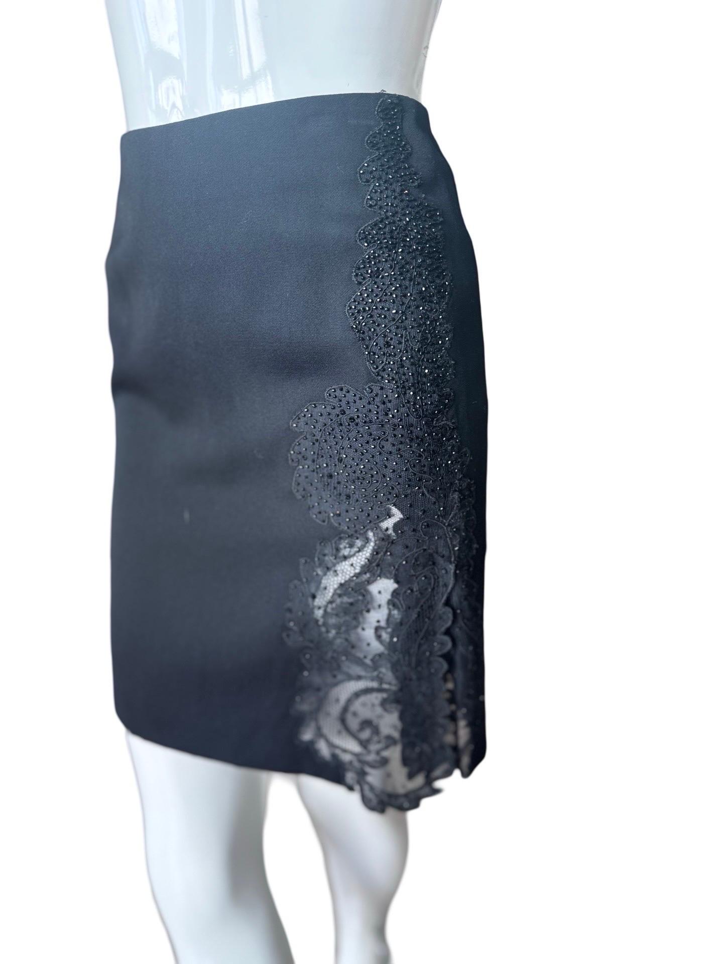 1990s mini skirt from Gianni Versace with a semi sheer panel on the one side of a lace and beaded applique.  The fabric is a light wool and is fully lined.  

A classic black mini skirt to have in your closet but with a twist!  Labelled an IT38 and