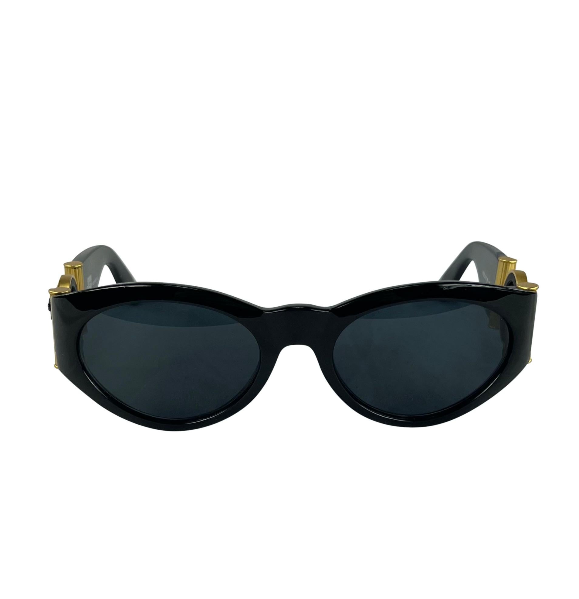 Designed by Gianni Versace in the 1990s, these black oval sunglasses are an ultra-chic addition to any wardrobe. Their sleek shape is accentuated by iconic gold-tone Versace Medusa reliefs adorning each arm. 

Approximate measurements:
Frame height: