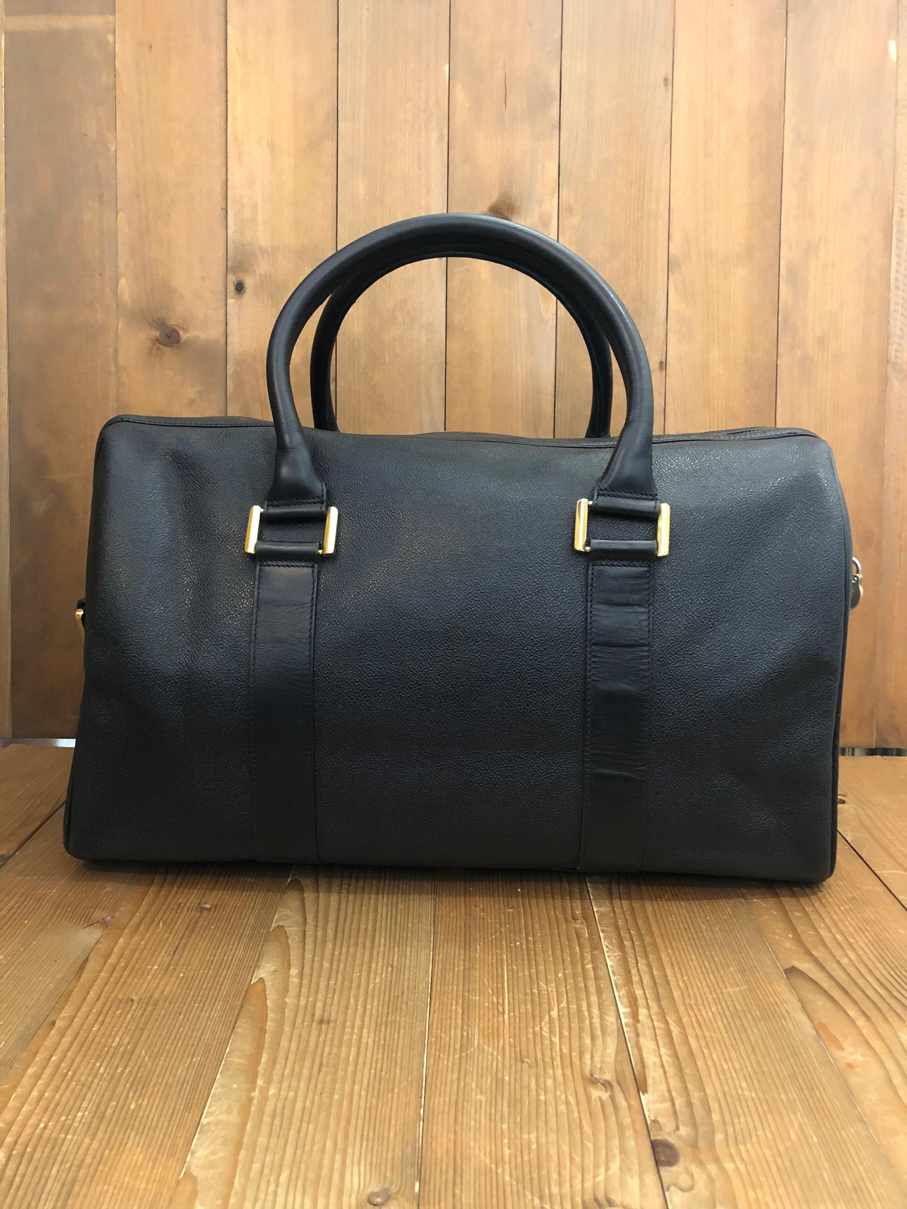 This vintage GIANNI VERSACE boston bag is crafted of textured leather in black featuring gold toned hardware. Top zipper closure opens to a black Gianni Versace jacquard interior featuring a zippered pocket. Cabin size. Perfect for a weekend