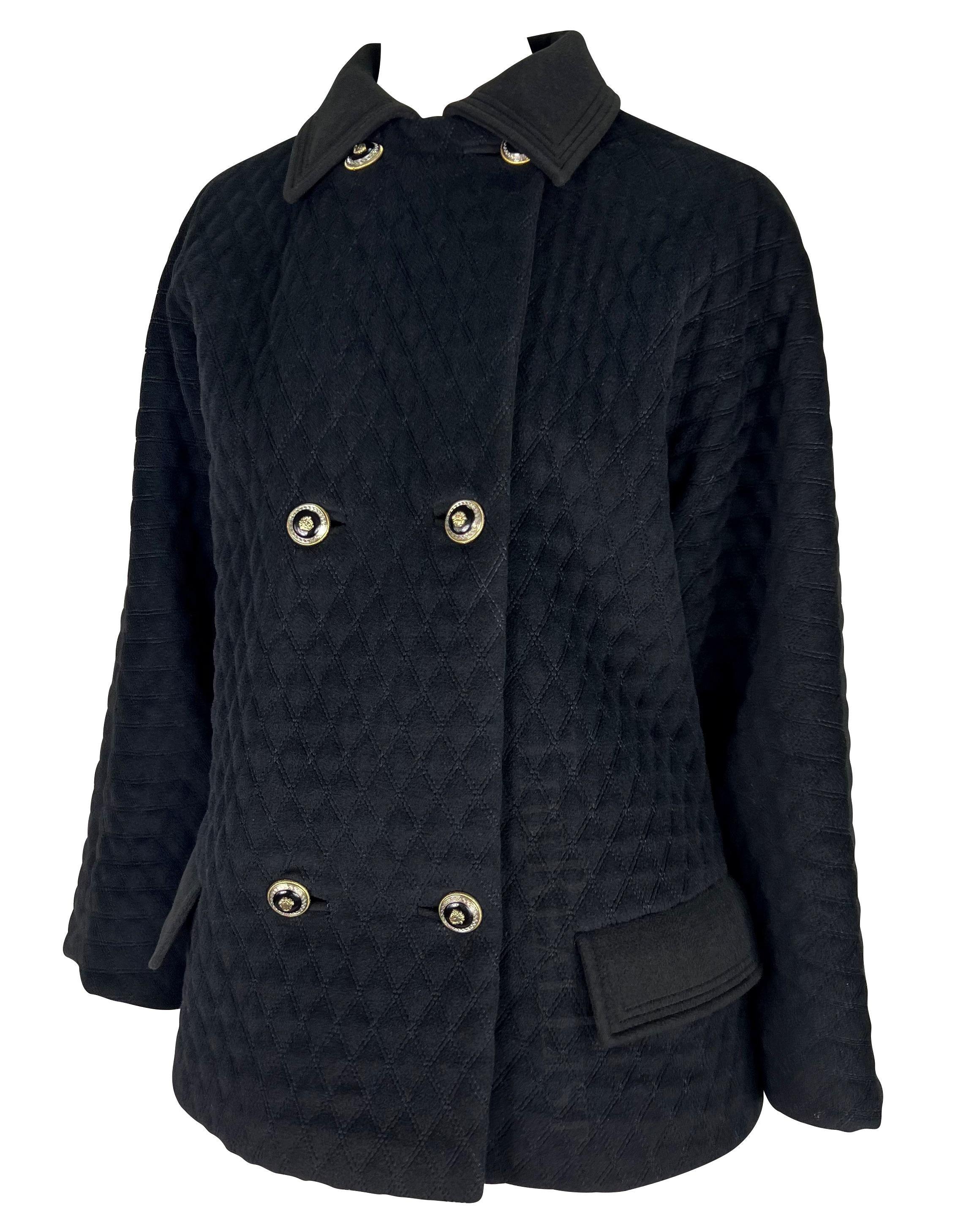Ti presentiamo un cappotto da auto Gianni Versace trapuntato nero, disegnato da Gianni Versace. Dagli anni '90, questo cappotto oversize offre un'estetica senza tempo. La chiusura a doppio petto, accentuata da bottoni dorati Versace Medusa in