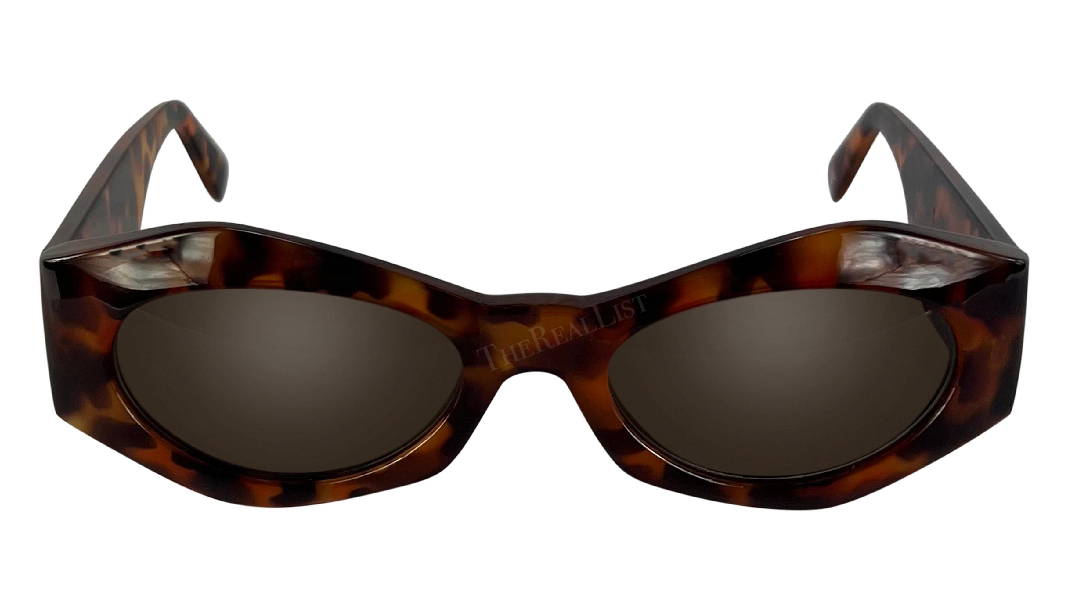 Designed by Gianni Versace in the 1990s, these angular faux-tortoise shell sunglasses are an ultra-chic addition to any wardrobe. Their sleek angular shape is accentuated by iconic gold-tone Versace Medusa relief adorning each arm. 

Approximate
