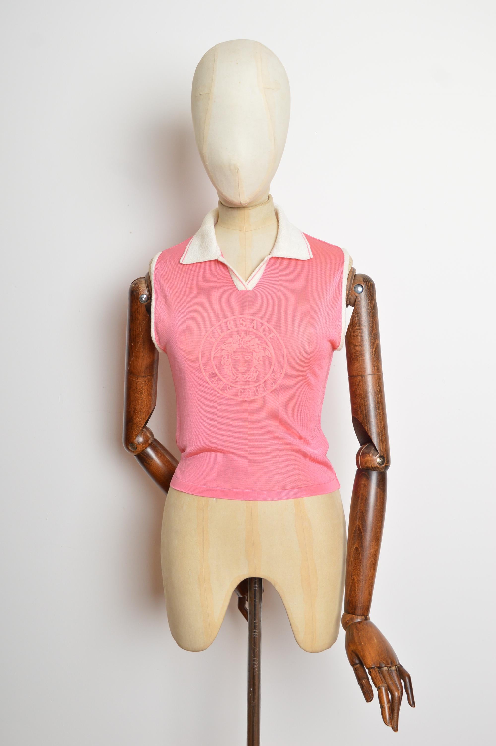 Un divertido polo Versace Jeans Couture de los años 90 en rosa chicle con un gran logotipo de Medusa impreso en la parte delantera, ribetes blancos en contraste y línea del cuello. 
Las medidas se indican en pulgadas ('')
Talla recomendada; Pequeña
