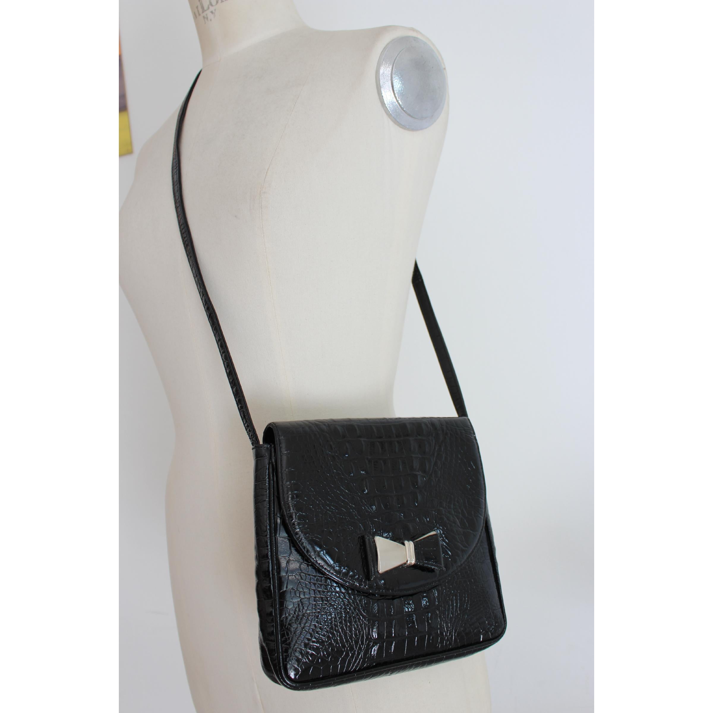 Gianni Versace Couture shoulder bag. Black color, 100% crocodile print leather. Closing with black and silver ribbon bow. Internally lined and logoed, zip pocket. 90s. Made in Italy. Excellent vintage conditions.

Width: 21 cm
Height: 20 cm
Depth: 4