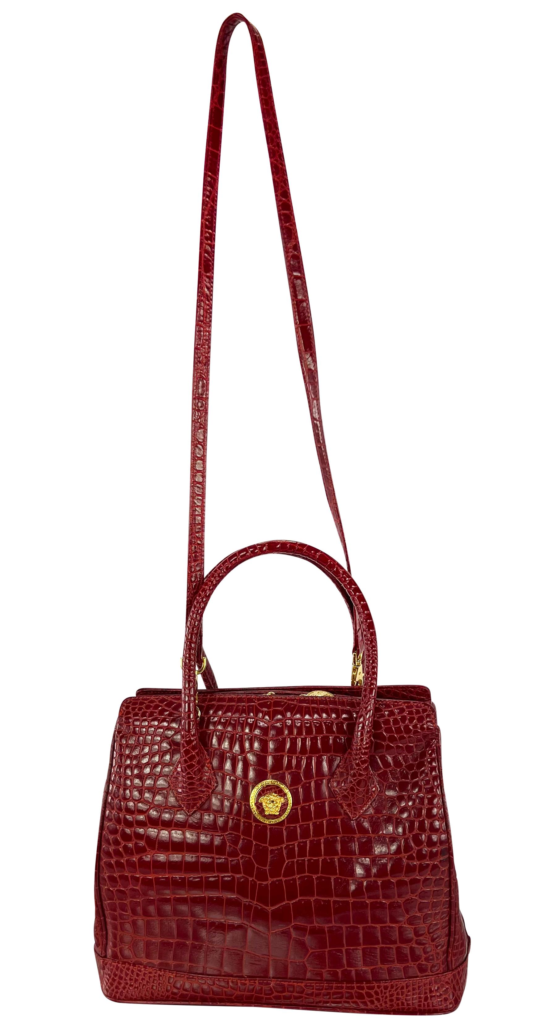 Ce sac à main Gianni Versace, conçu dans les années 1990, est orné d'un crocodile d'un rouge éclatant. Réalisé en cuir rouge vif, il arbore une Méduse dorée sur le devant et dispose d'une lanière supplémentaire qui permet de le styliser et de le