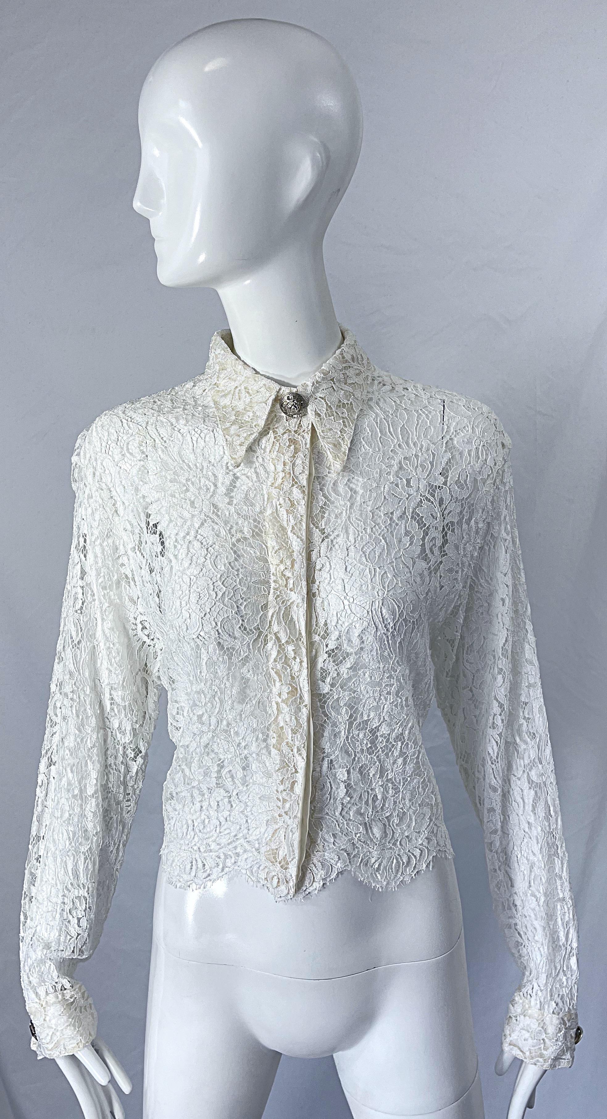 Sexy and rare early 1990s GIANNI VERSACE COUTURE white lace sheer blouse ! Features silk French chantiliy lace with hidden buttons up the front center. Large silver Medusa buttons at center collar and at each sleeve cuff. 
Can easily be dressed up